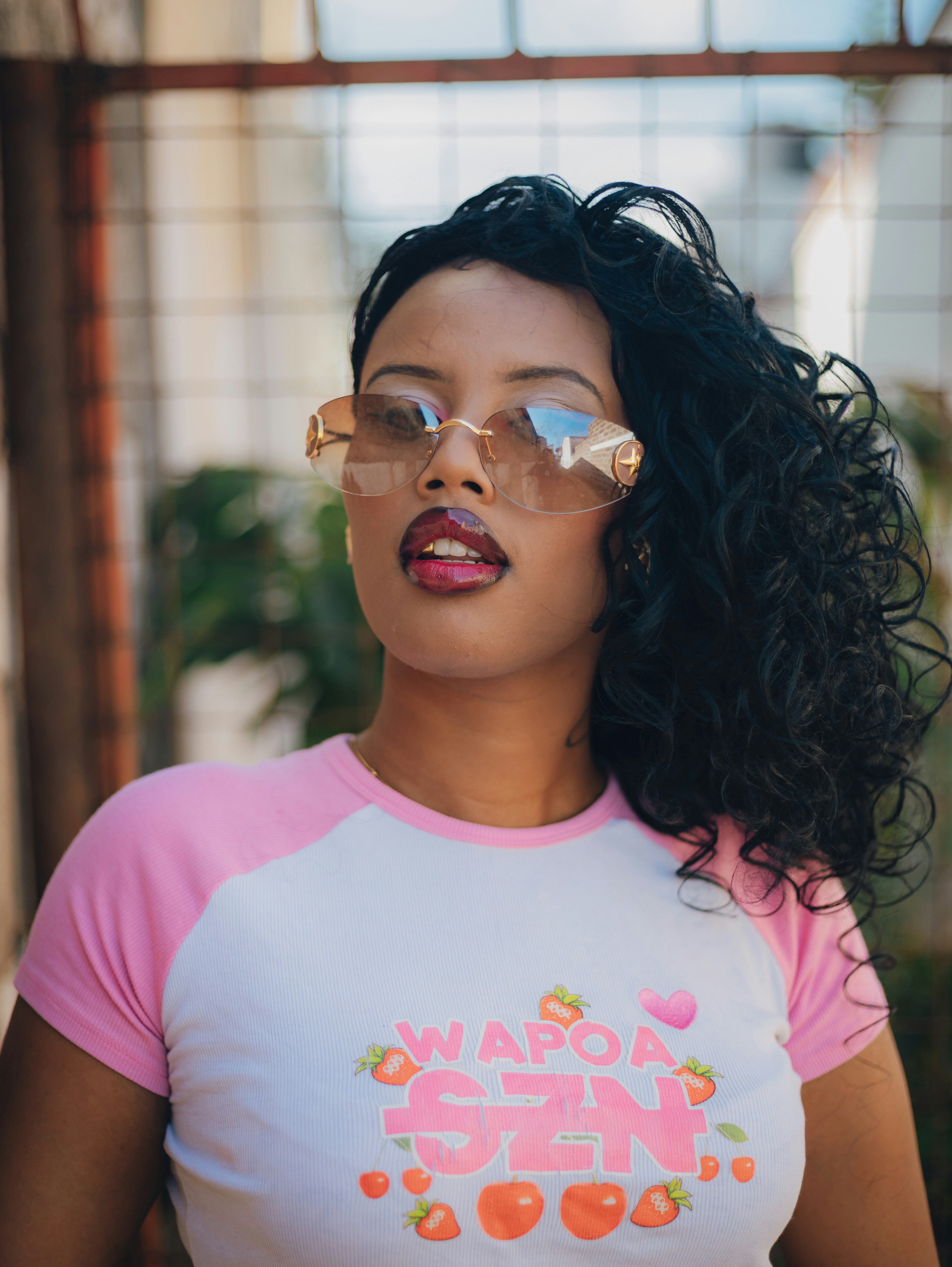A woman wearing sunglasses and a pink and white shirt. photo – Free ...