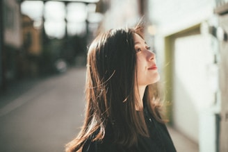 Young woman looking up outdoors with hair blowing