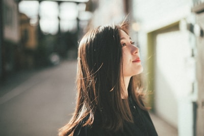 Young woman looking up outdoors with hair blowing