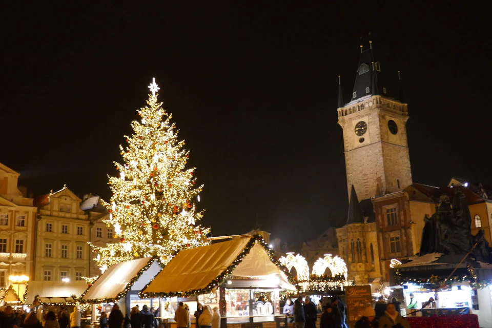 The Christmas tree and market stalls on Old Town Square in Prague, below the Old Town Hall tower.
