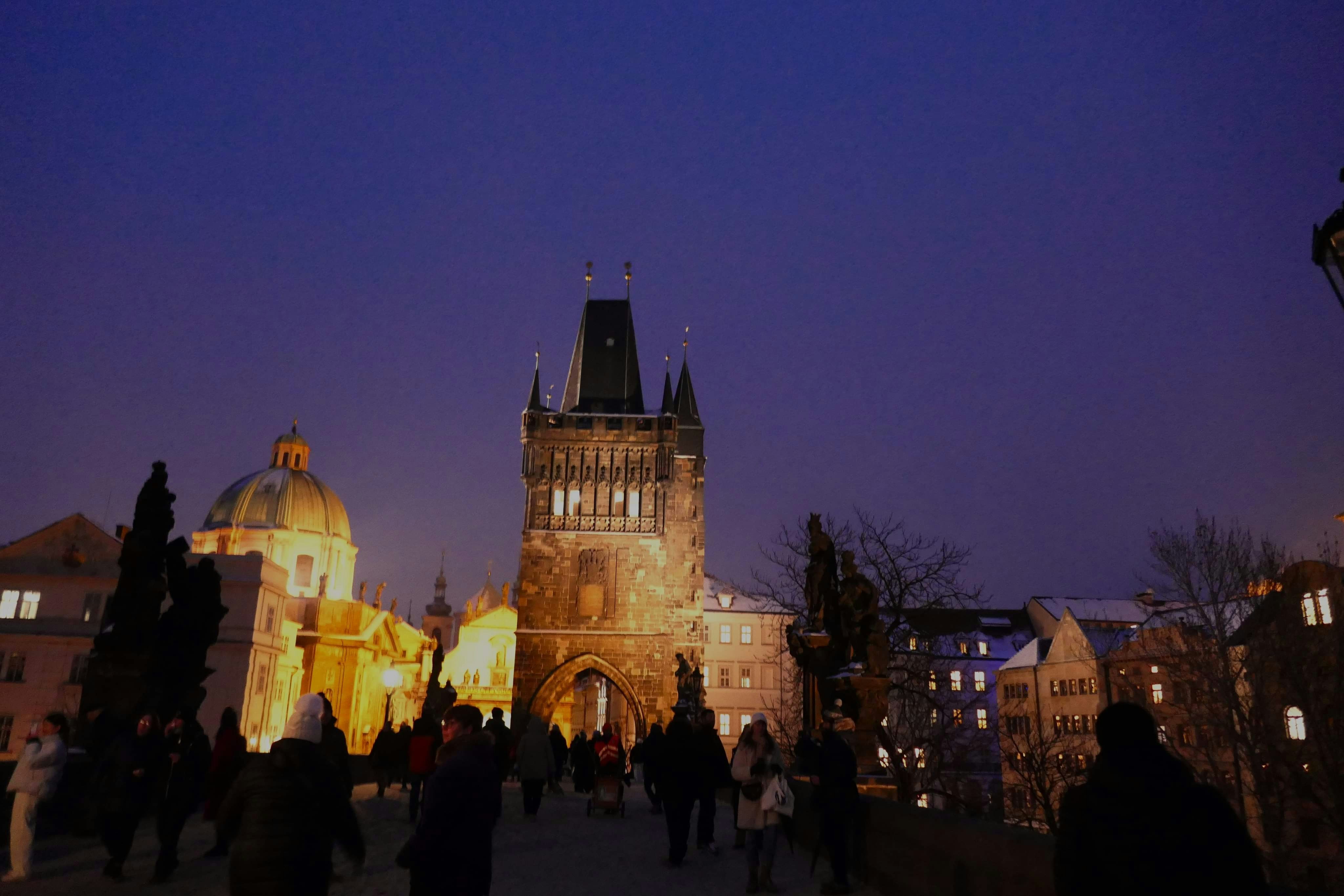 People walking across a bridge at night