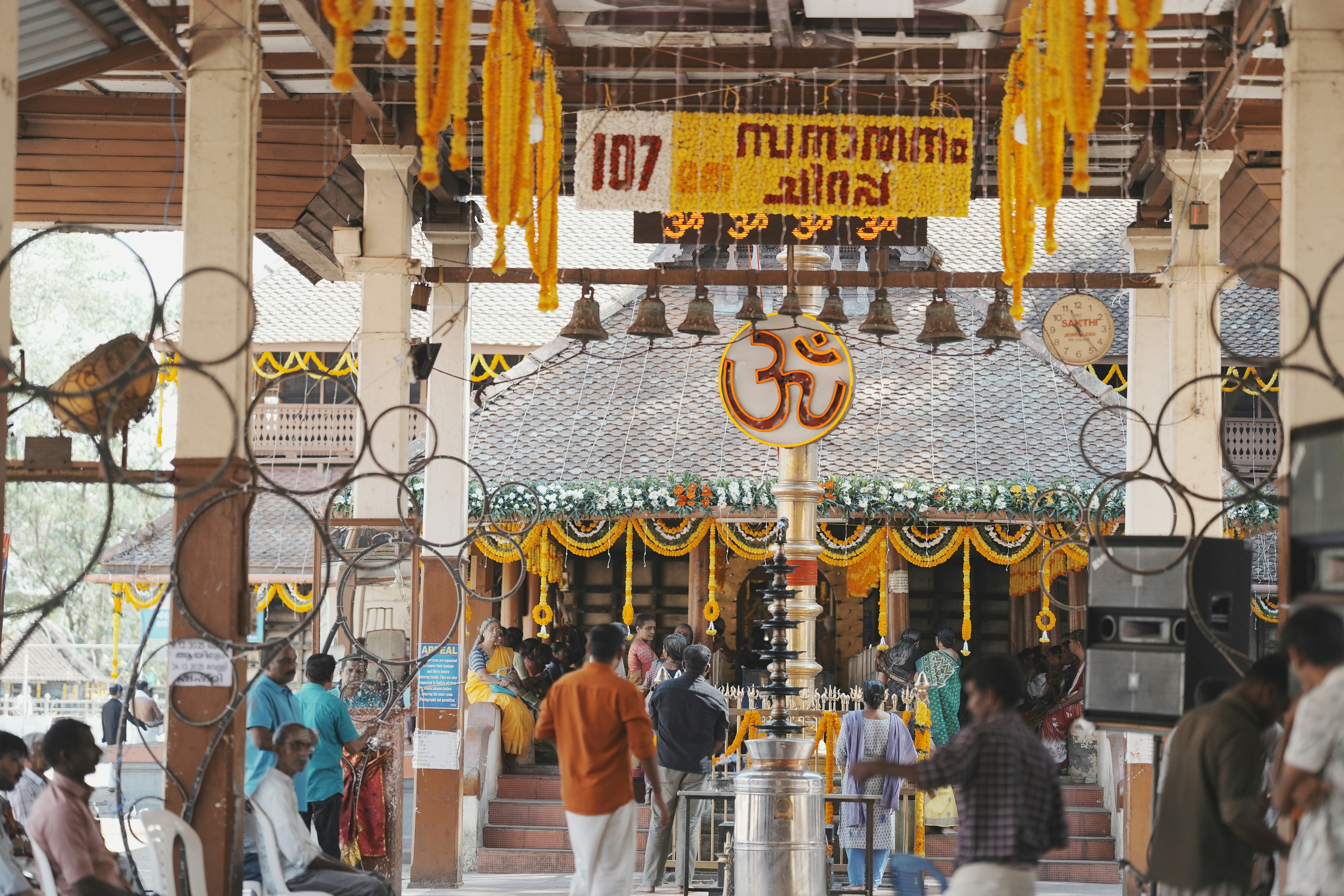 People gathered at a temple with yellow decorations.
