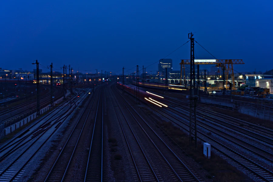 Rail yard at dusk where two freight networks converge, after a post-acquisition 3PL integration
