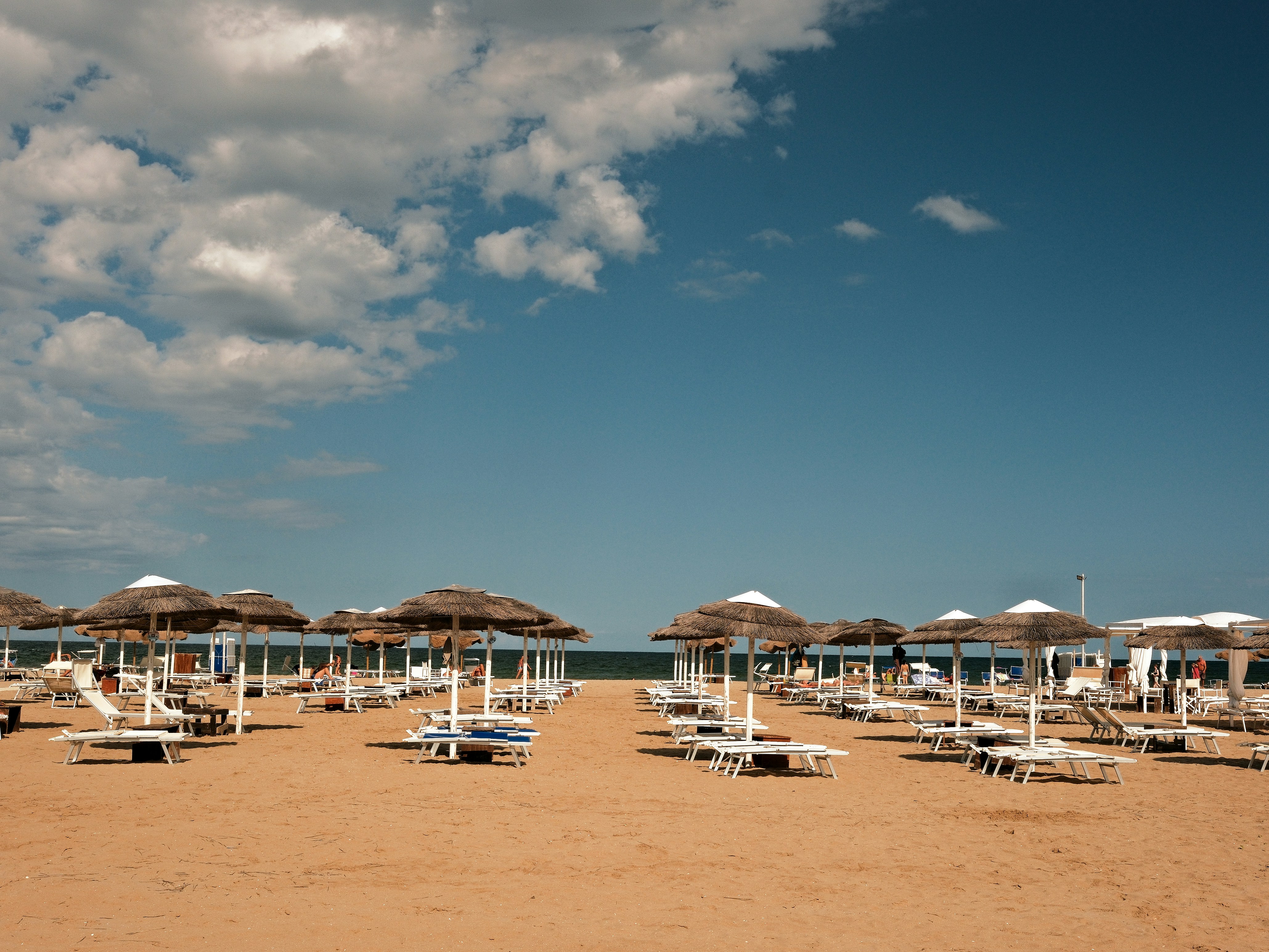 Spiaggia con molte sdraiole e ombrelloni