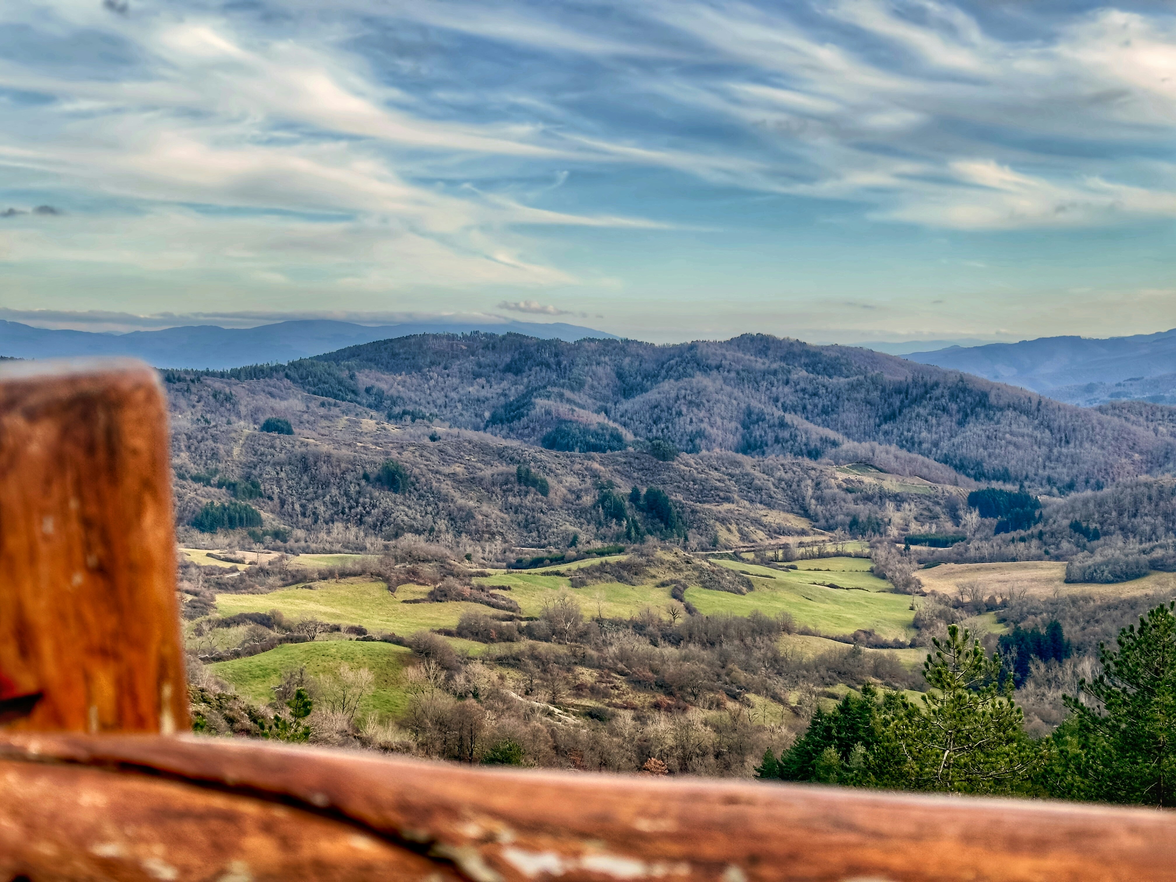 Rolling hills and green fields under a cloudy sky