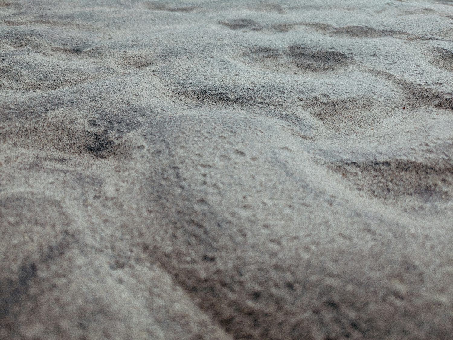 Grey, wavy, bumpy sand, which is pitted in places. There are varying valleys and troughs in the surface.