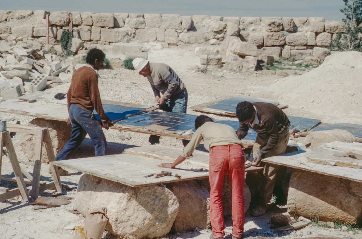 Employees working on large stone slabs outdoors