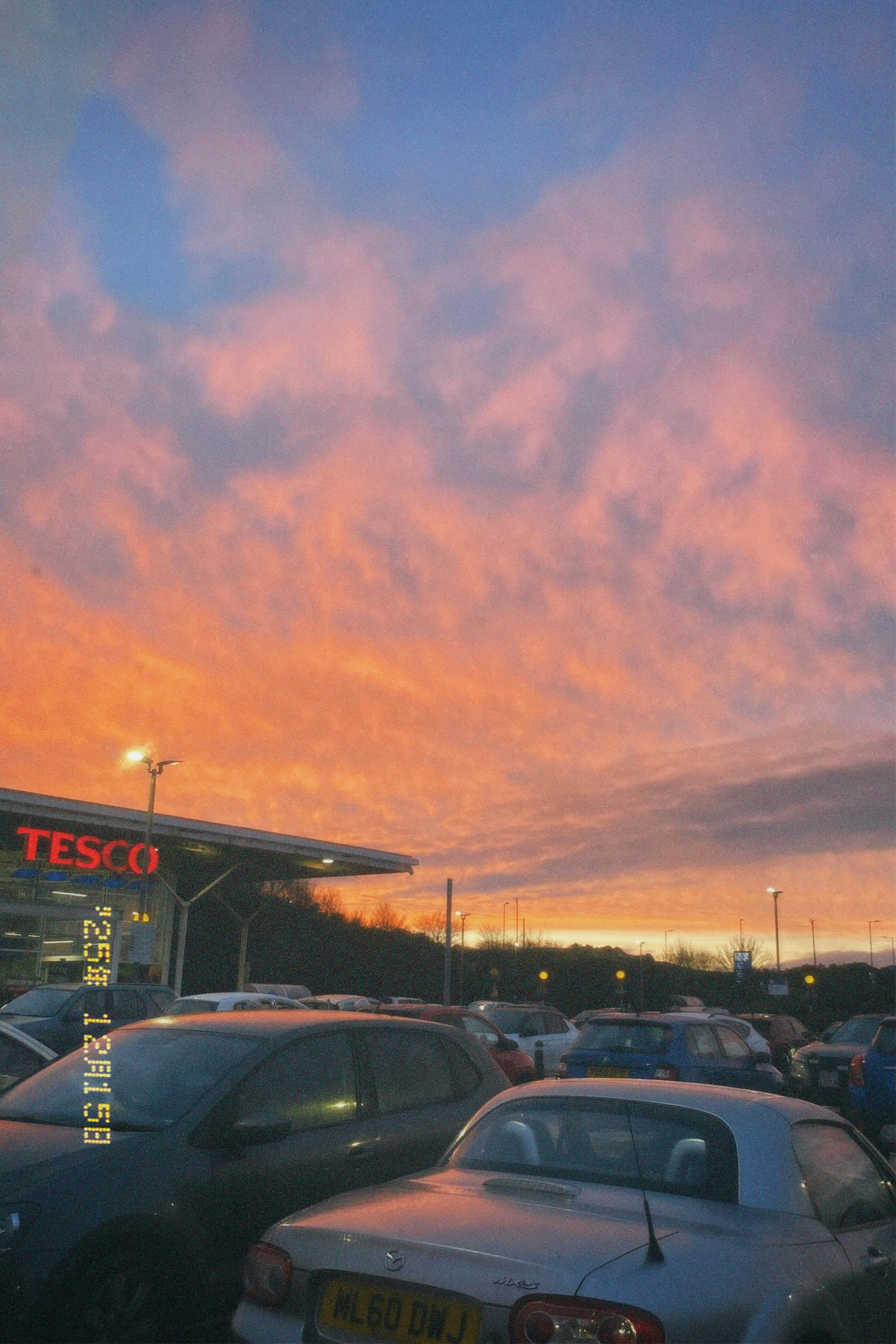Cars in a parking lot during a vibrant sunset