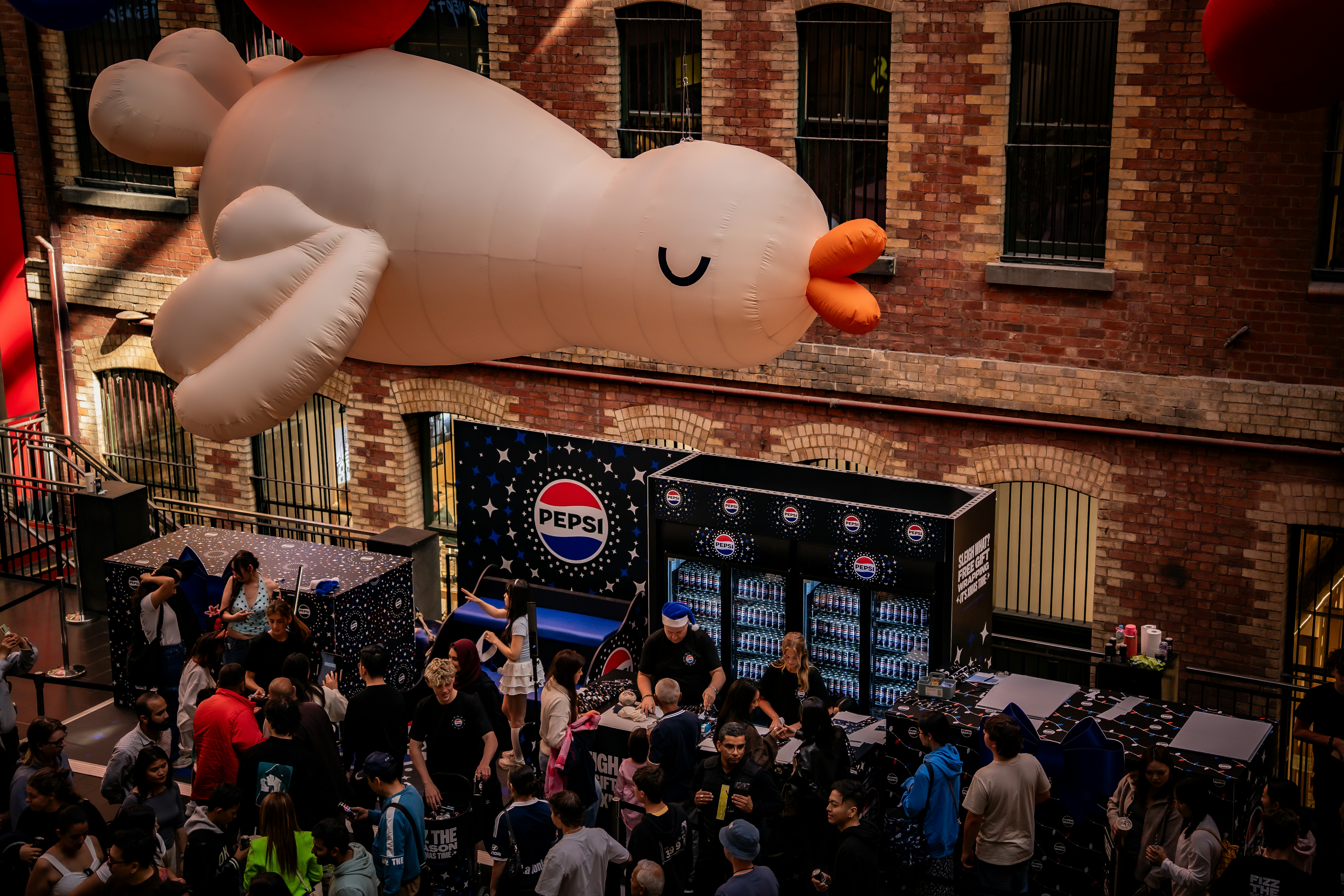 Giant inflatable bird floats over a crowded street event