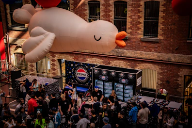 Giant inflatable bird floats over a crowded street event