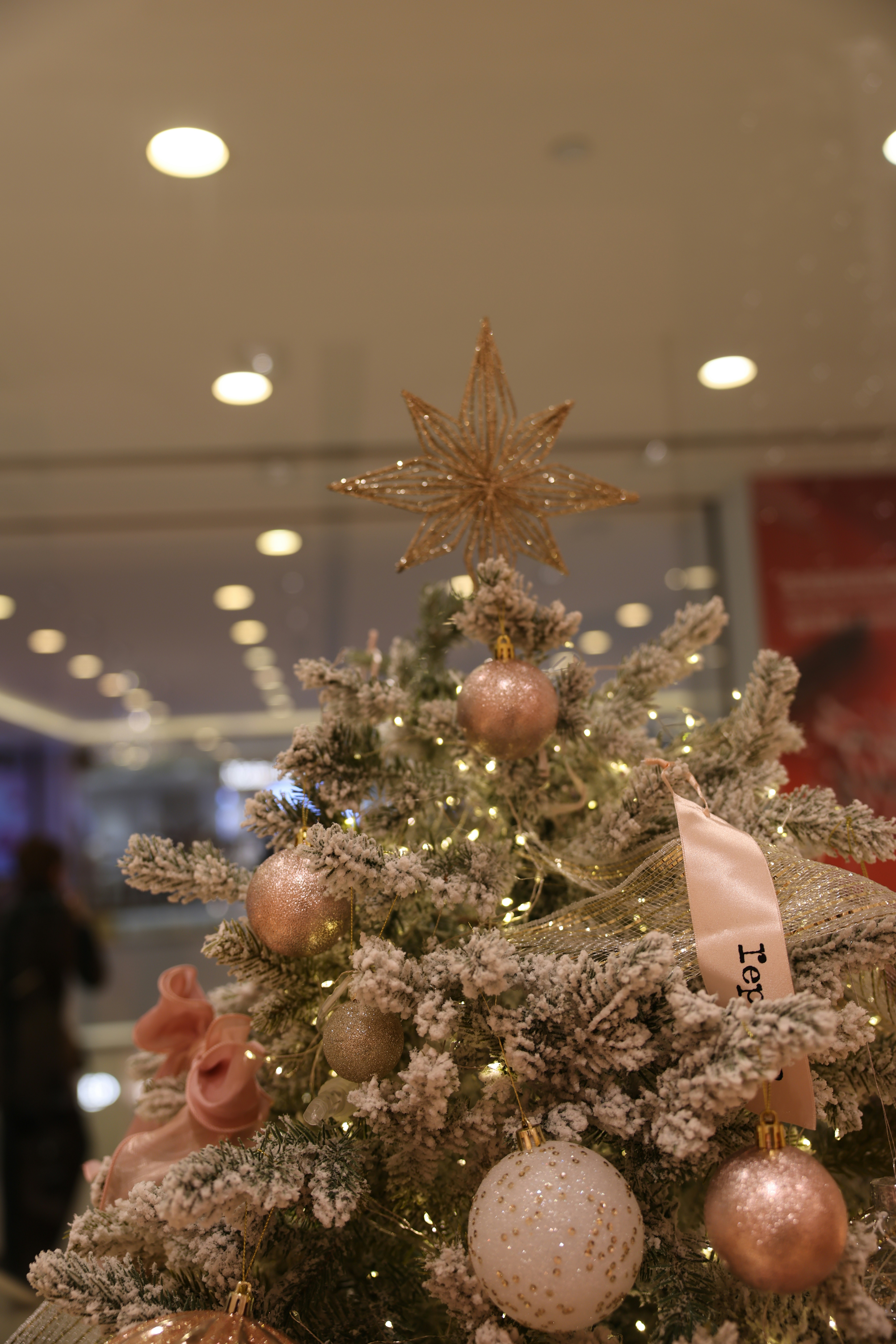 A decorated christmas tree with pink ornaments and lights.