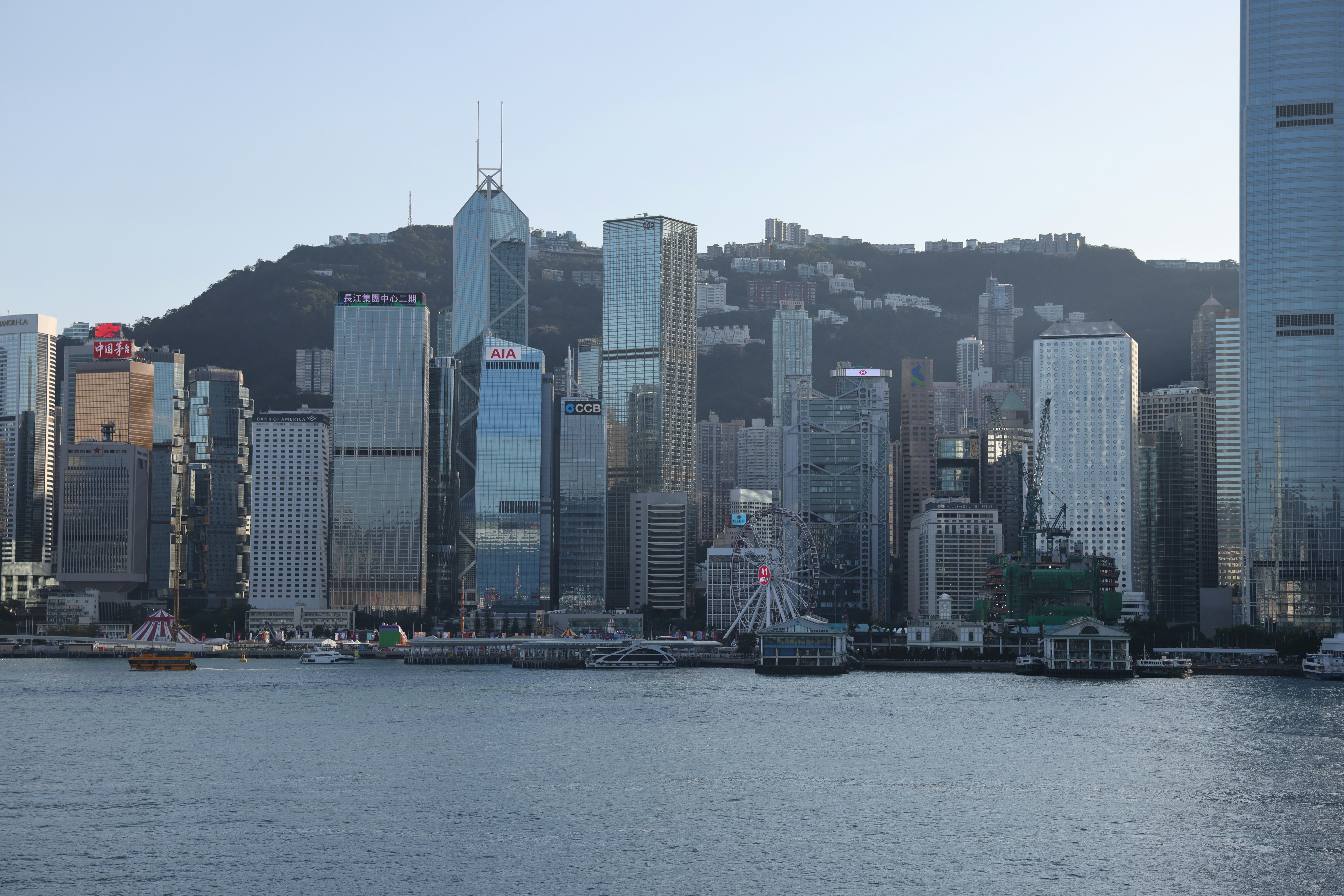 Modern skyscrapers rise behind a harbor in hong kong.