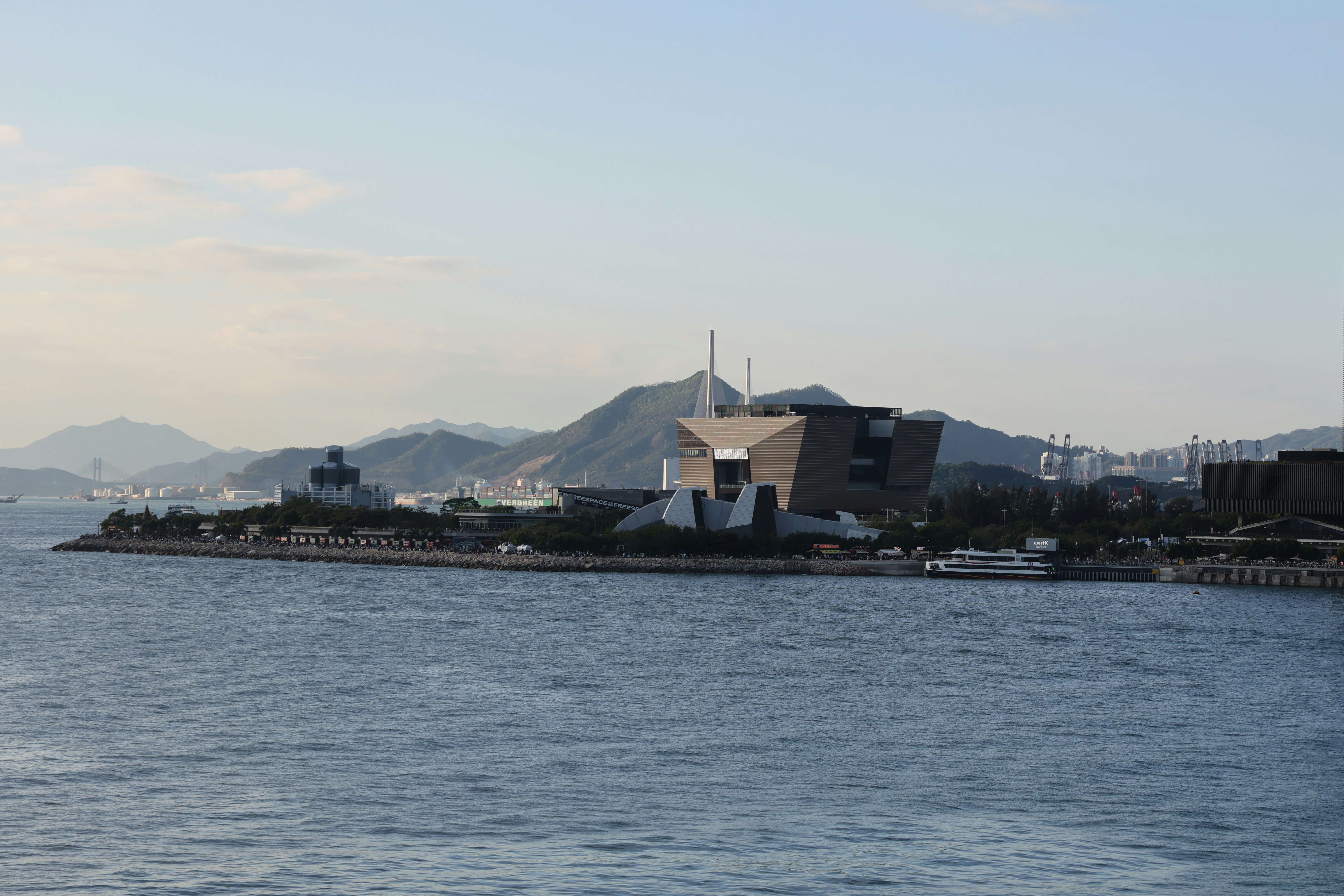 Modern building on a peninsula with mountains behind