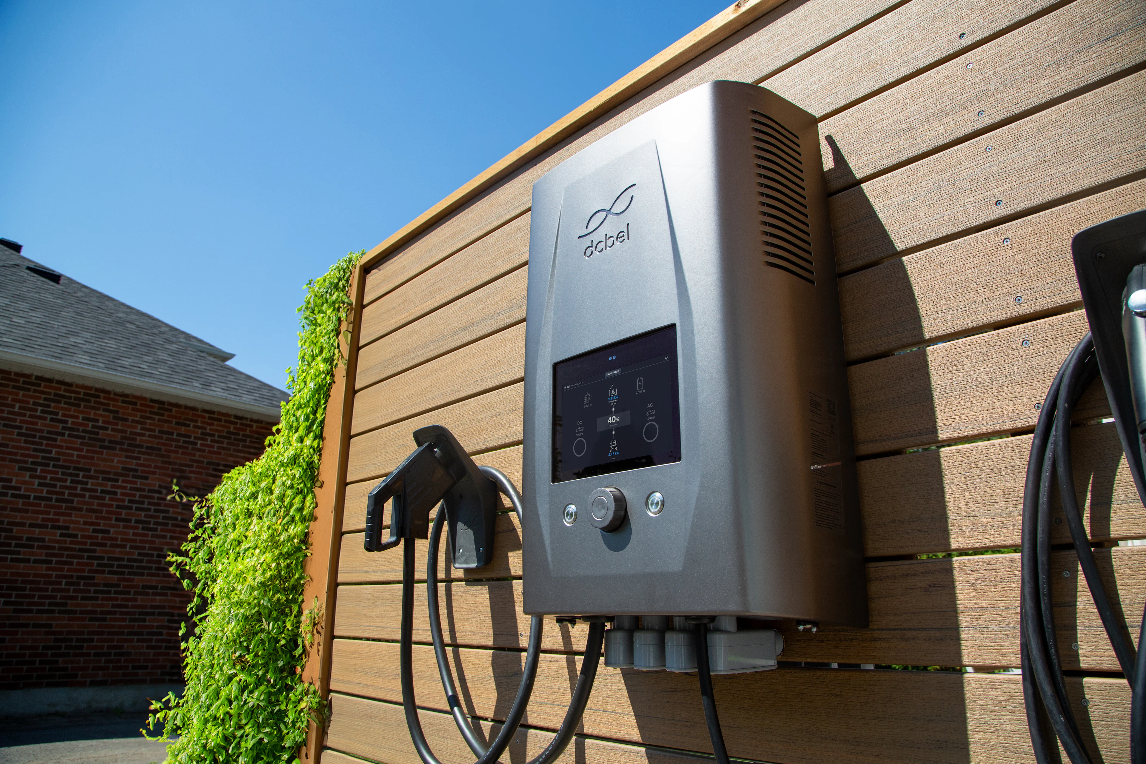 Borne de recharge murale installée sur la façade d'une maison