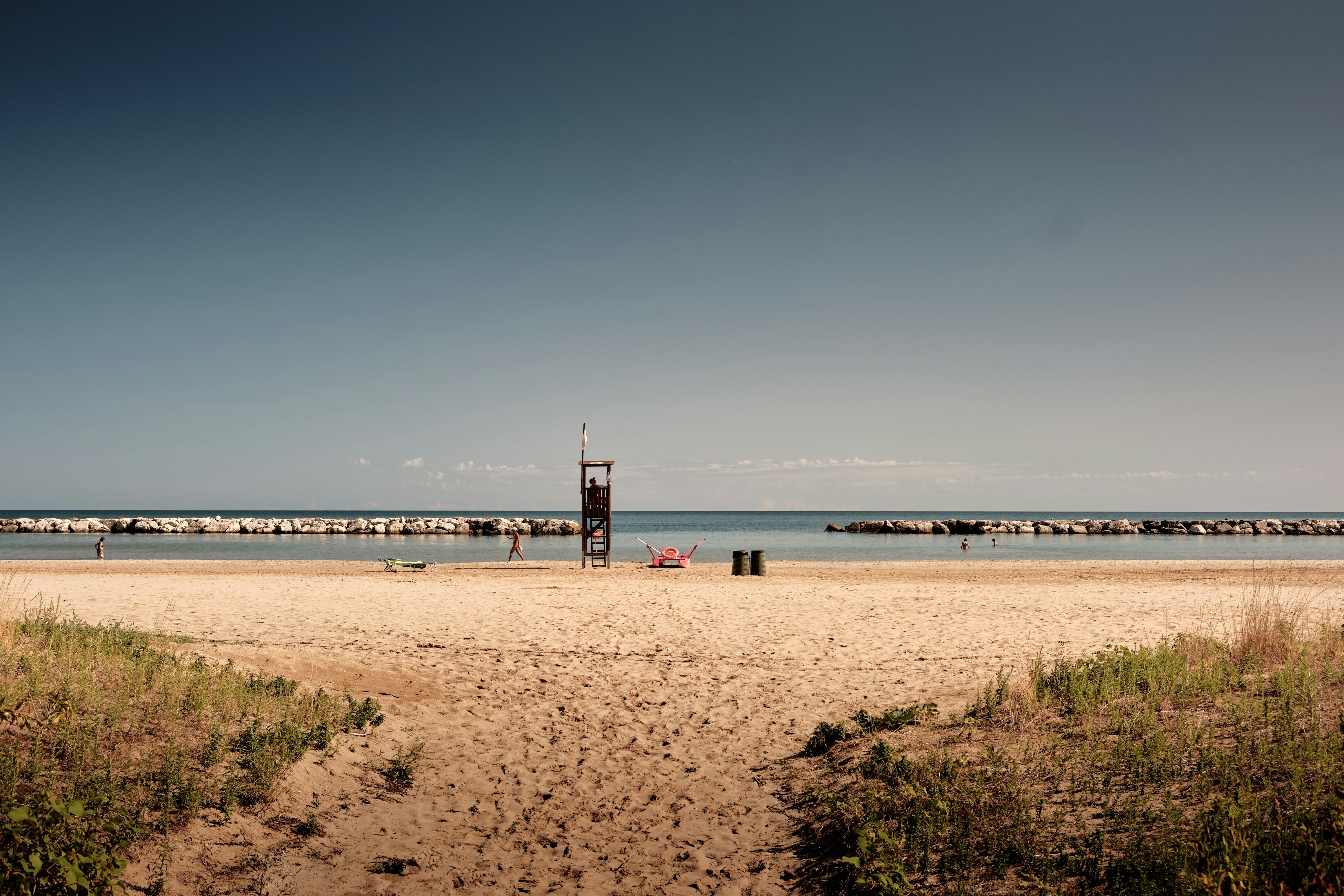 Torre dei bagnini su una spiaggia sabbiosa con onde dell'oceano.