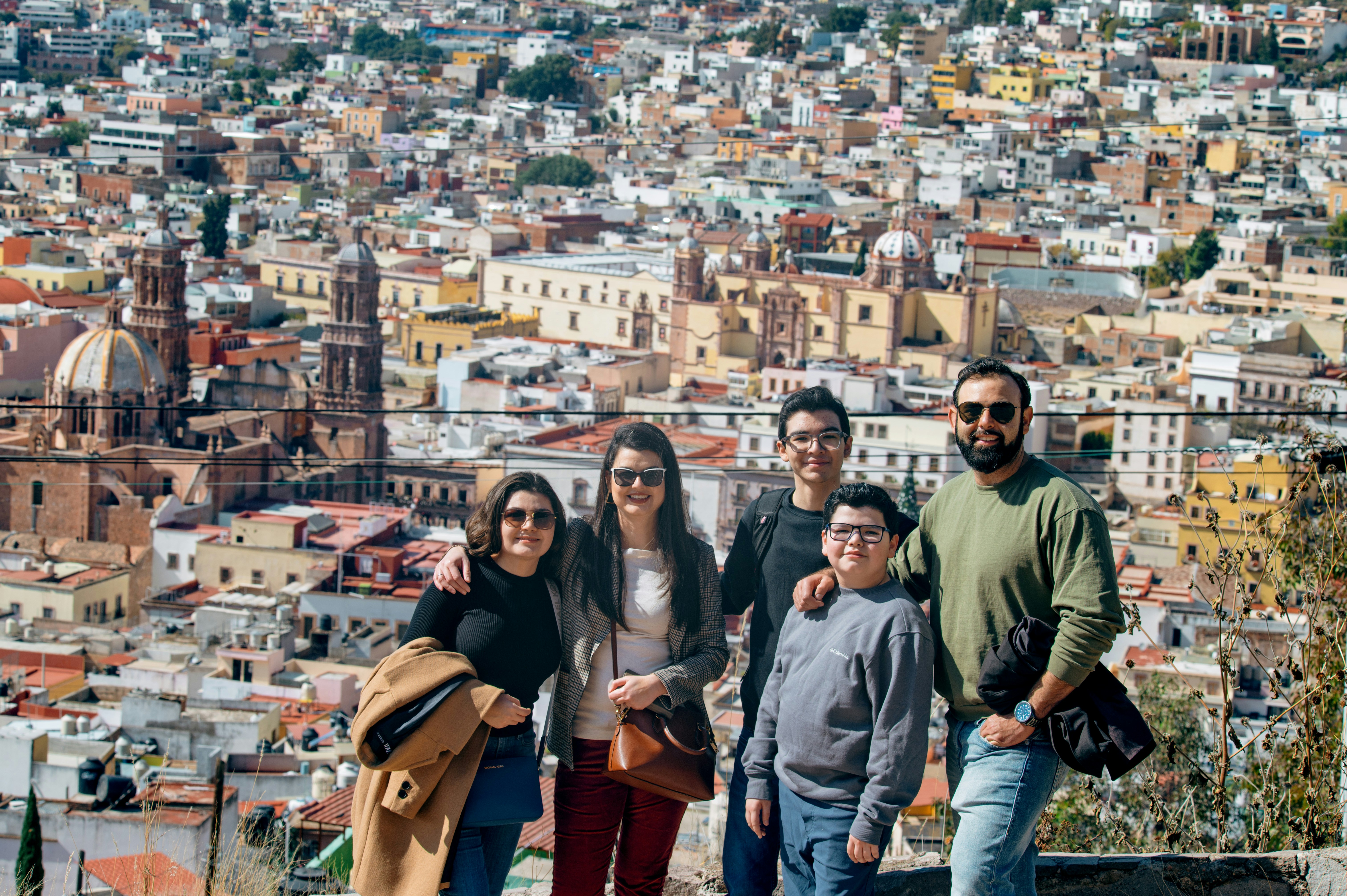 Family posing with a city view in the background.