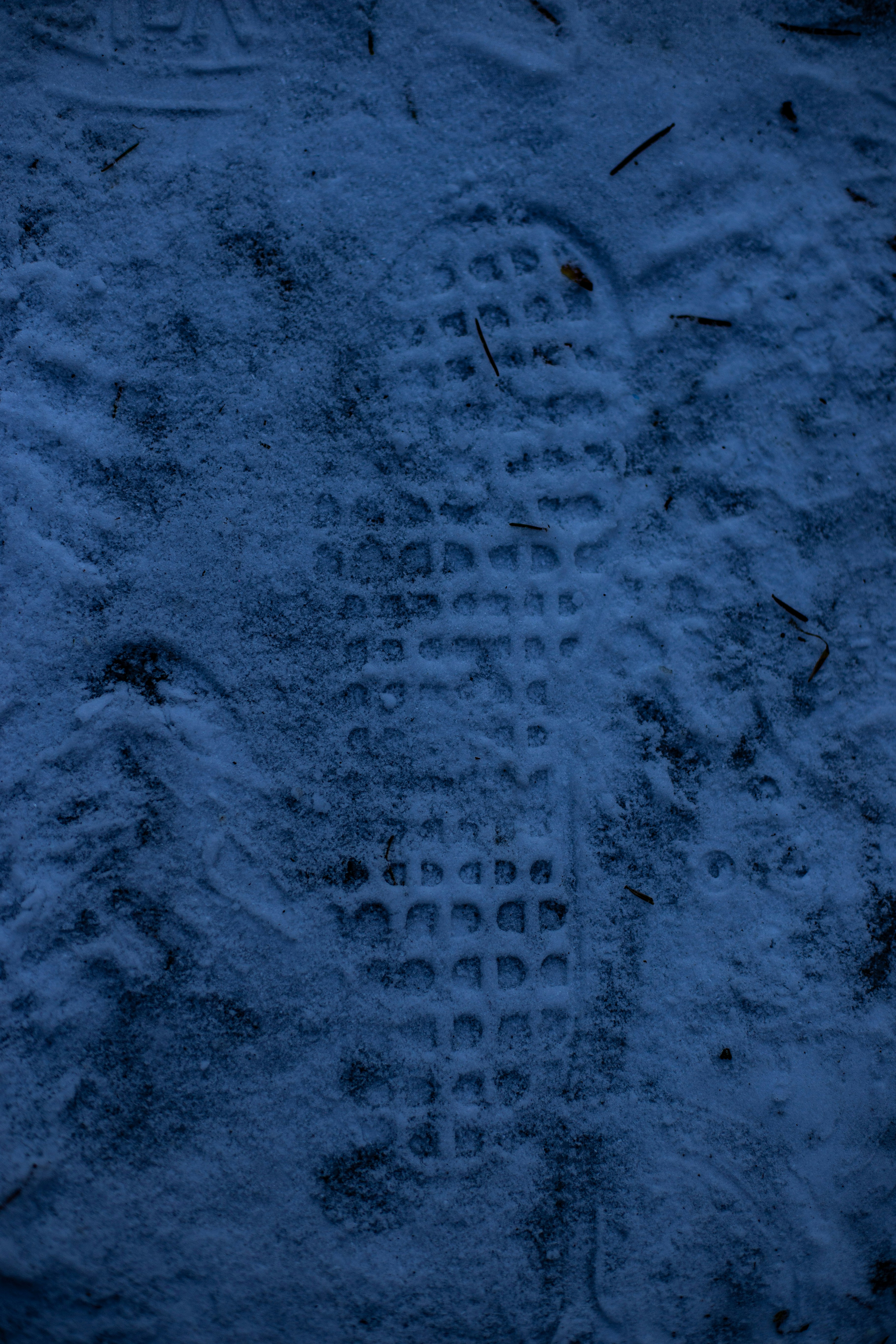 Ein einzelner Schuhabdruck im Schnee.