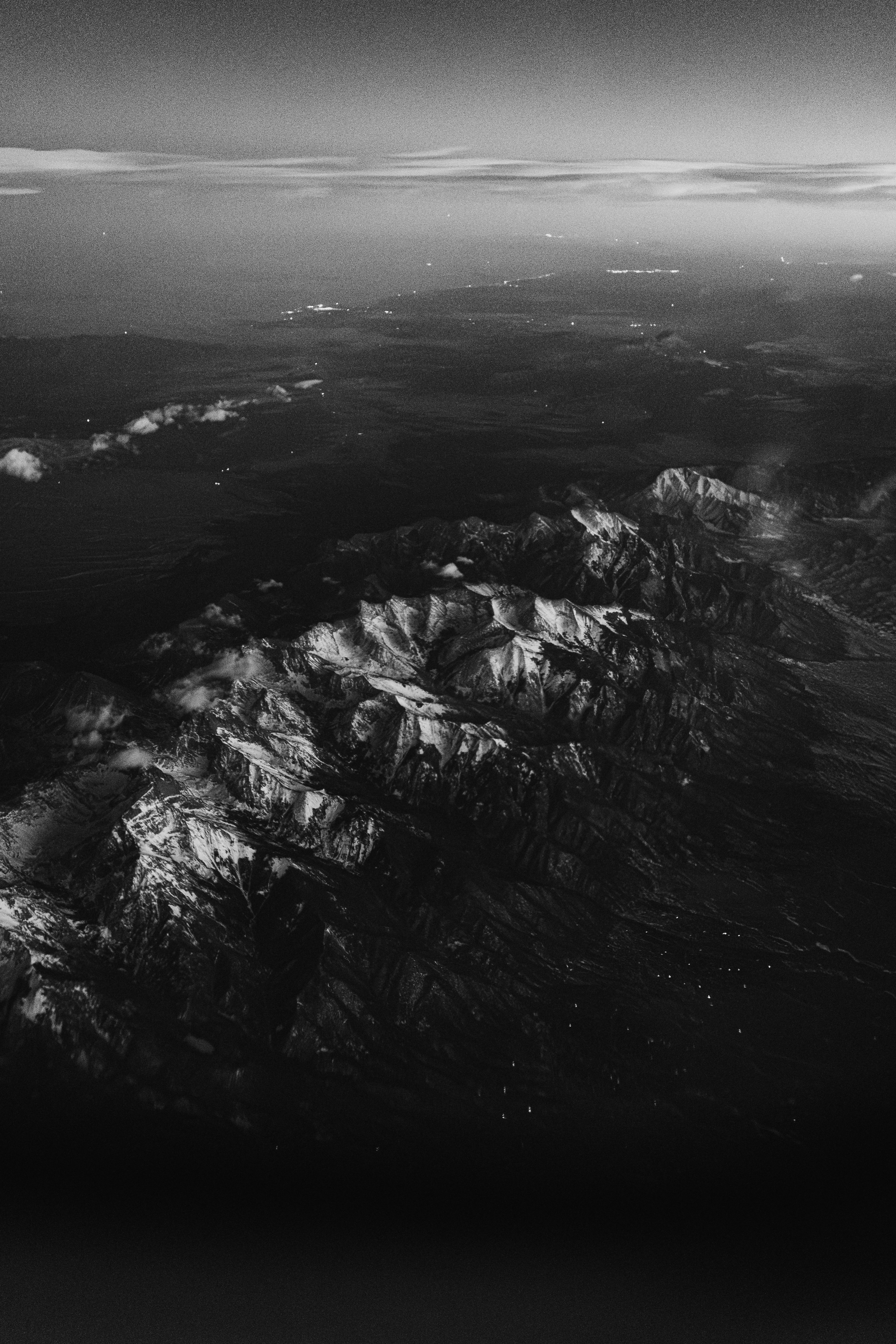 Snow-capped mountains seen from above at high altitude.