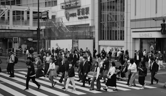 Crowd of people crossing a busy street at crosswalk.