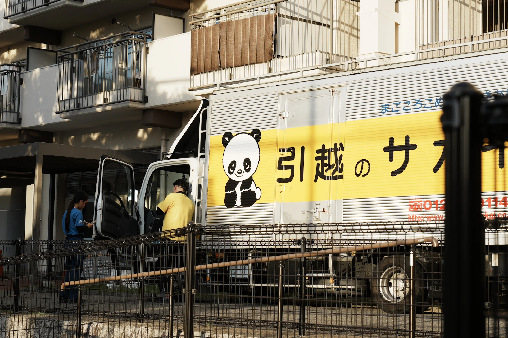 A delivery truck with a panda logo and japanese text.