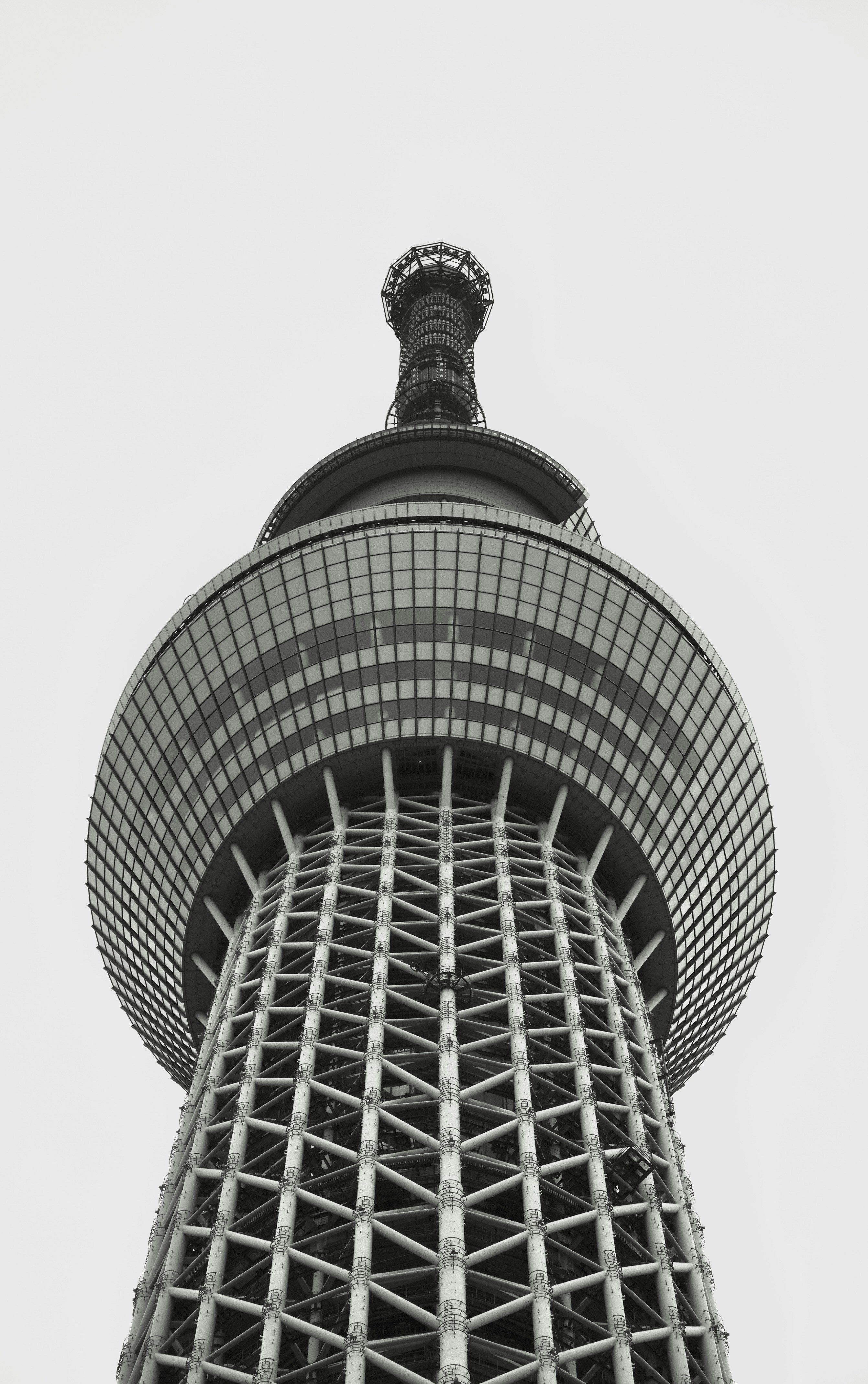 Low angle view of a modern tower against overcast sky