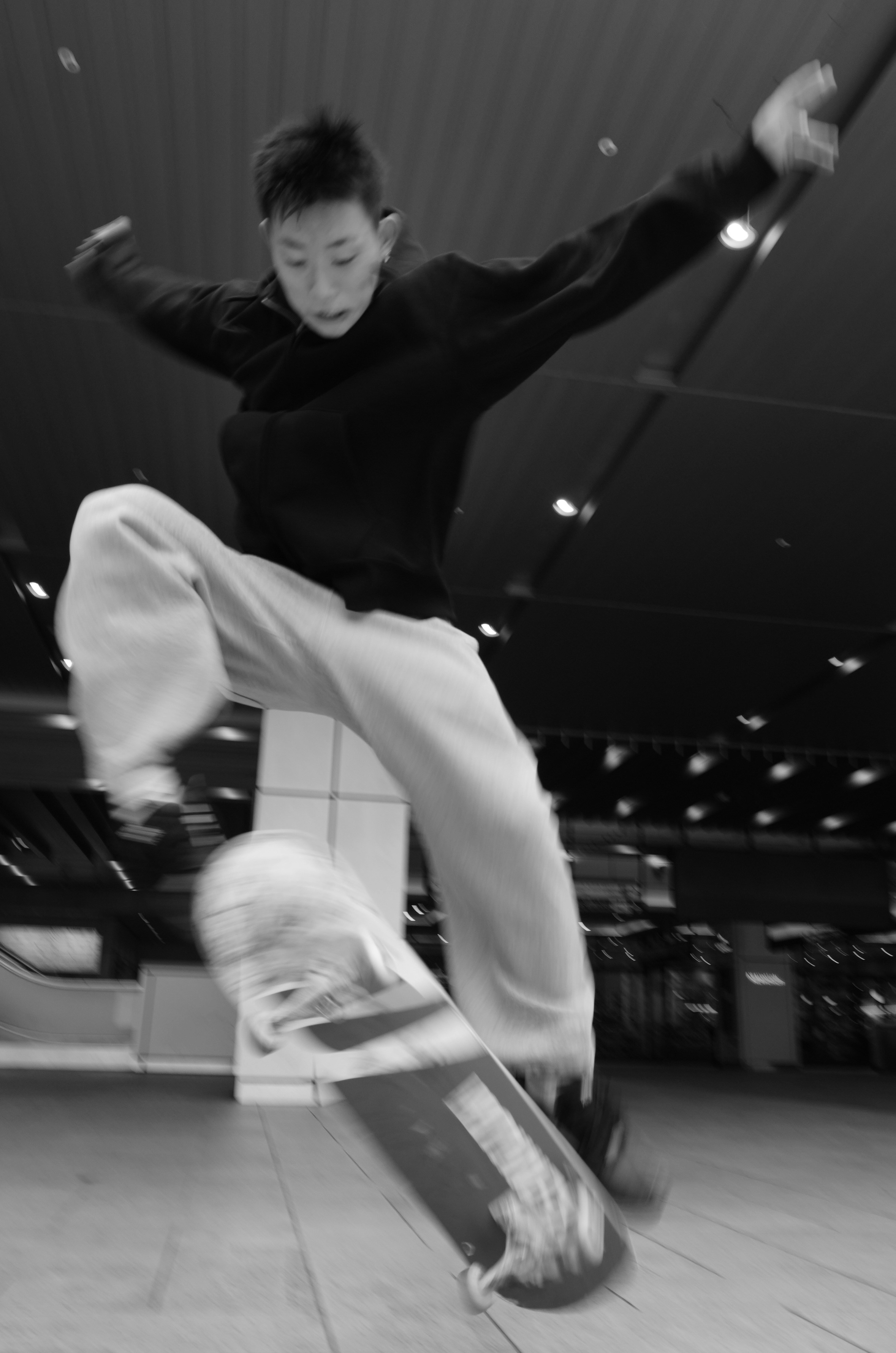 Young person performing a skateboard trick indoors
