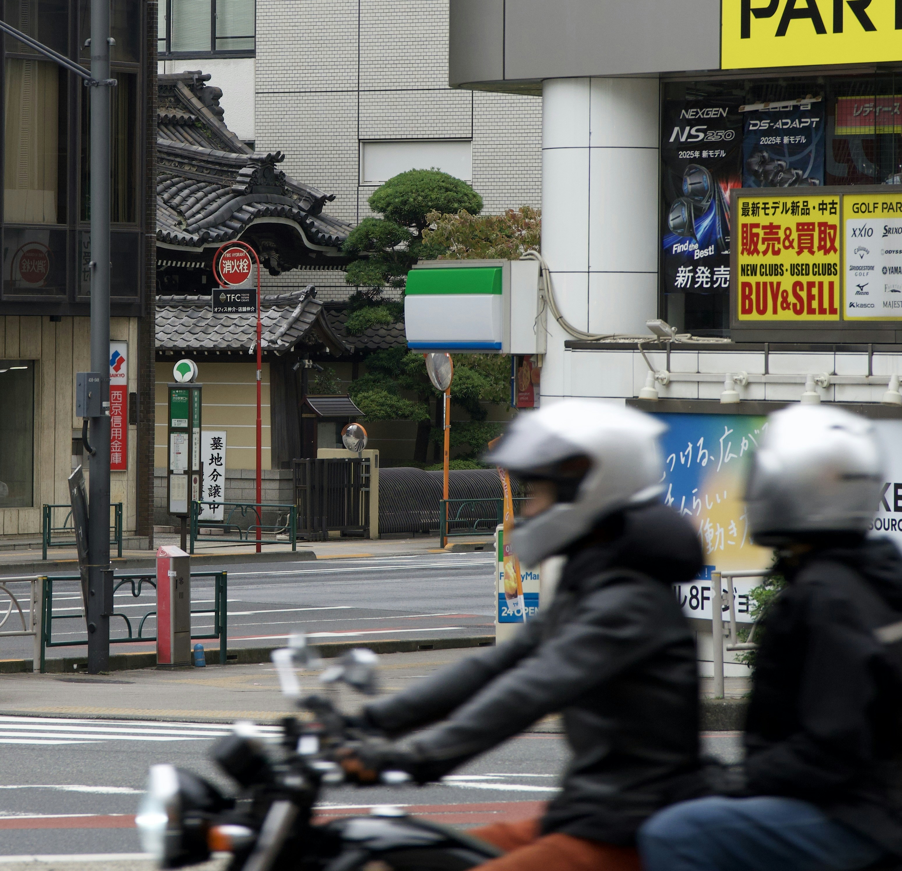 Two people riding a motorcycle on a city street.