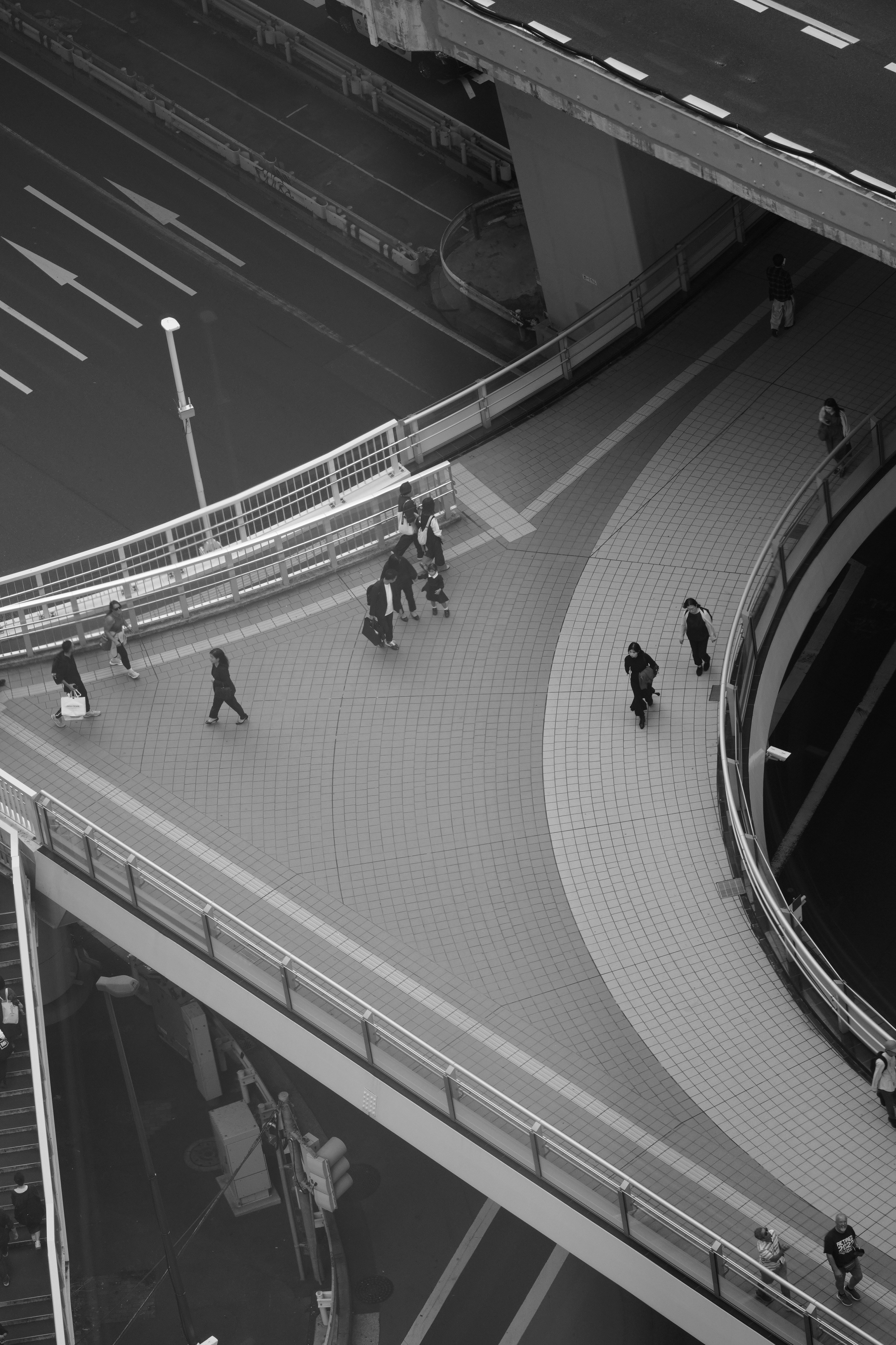 People walking on elevated pedestrian walkways in a city.