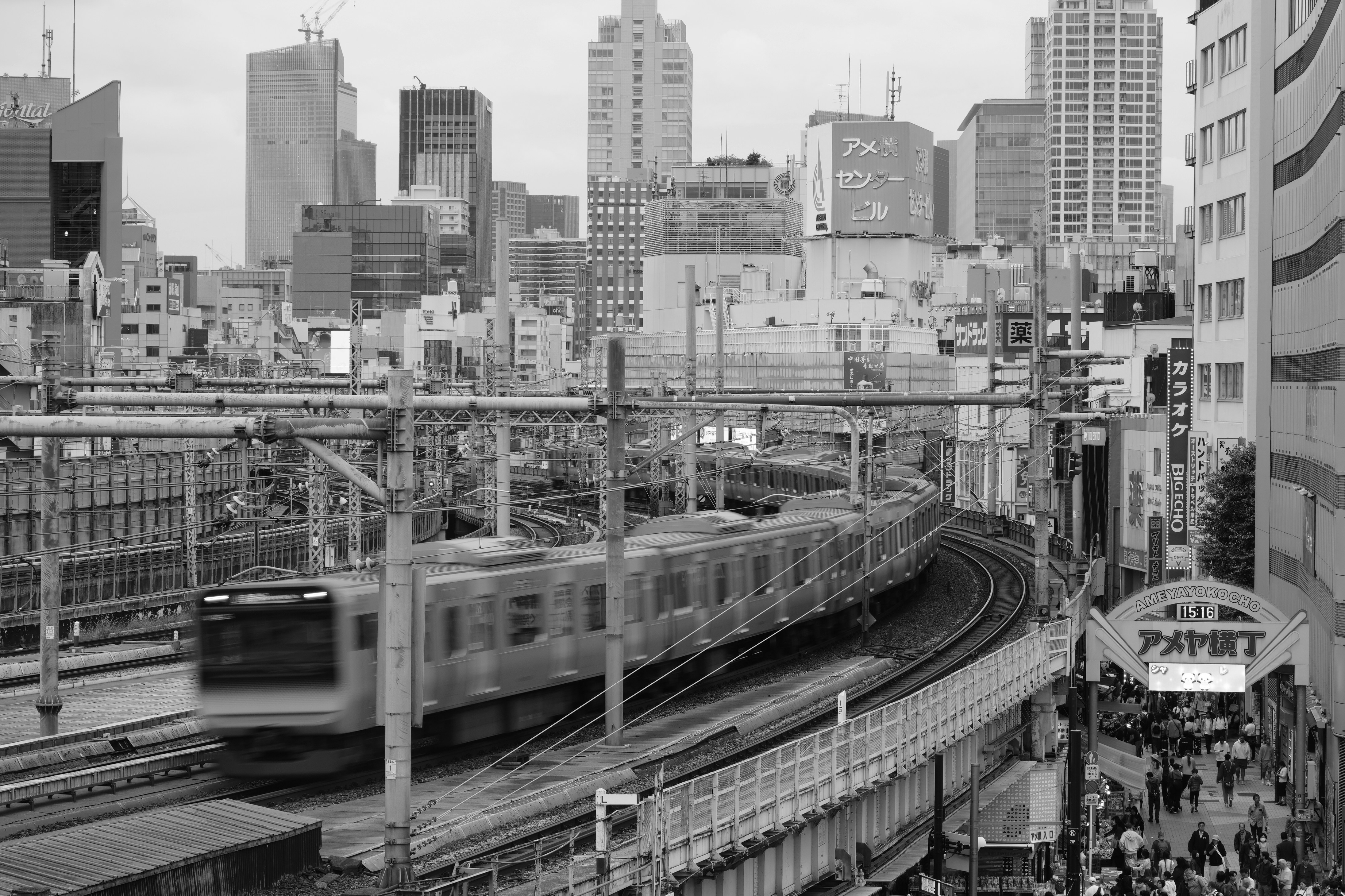Train moving through a city with tall buildings.