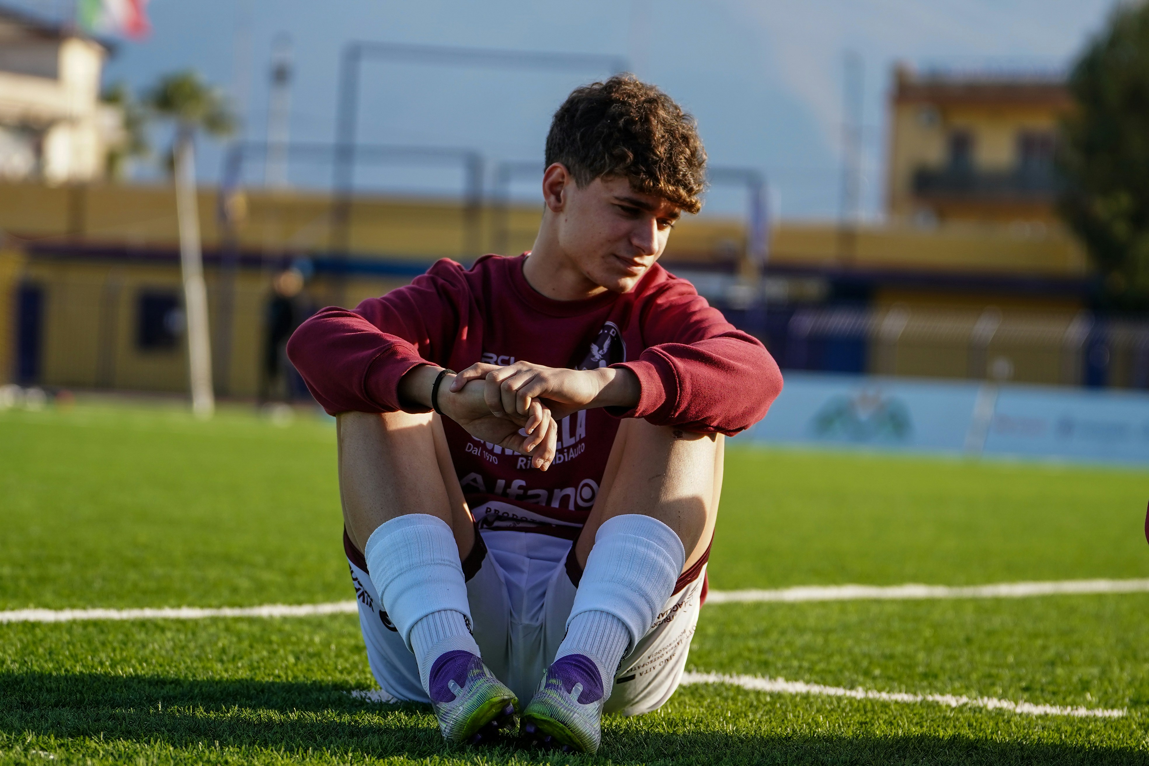Young boy sitting on a soccer field
