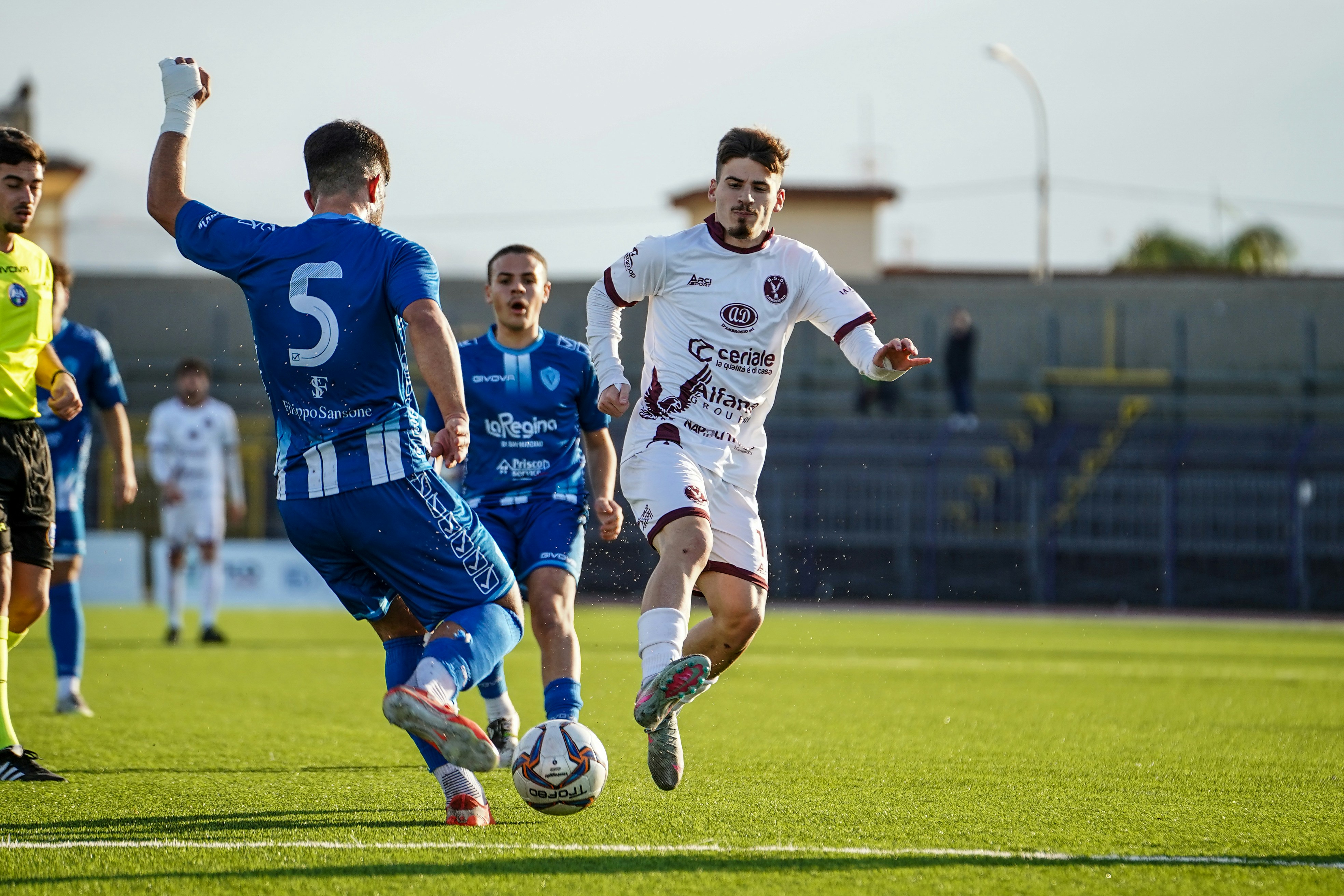 Soccer players competing for the ball on a field.