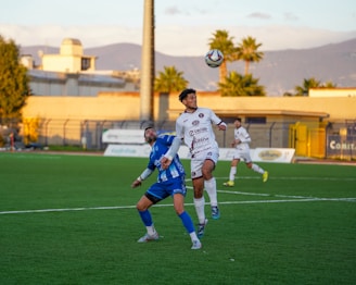 Two soccer players jumping for a header