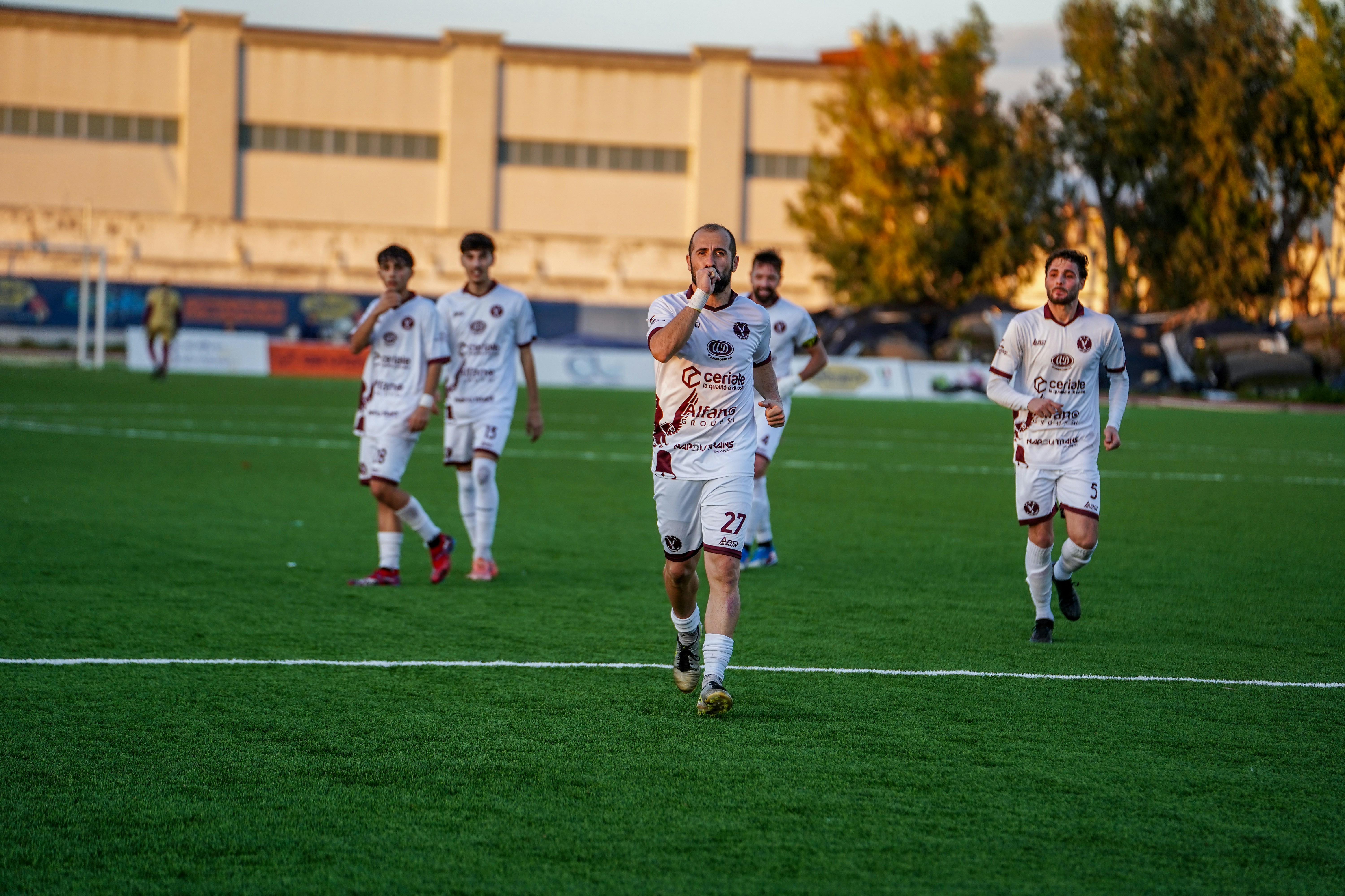 Soccer players in white uniforms on a field.