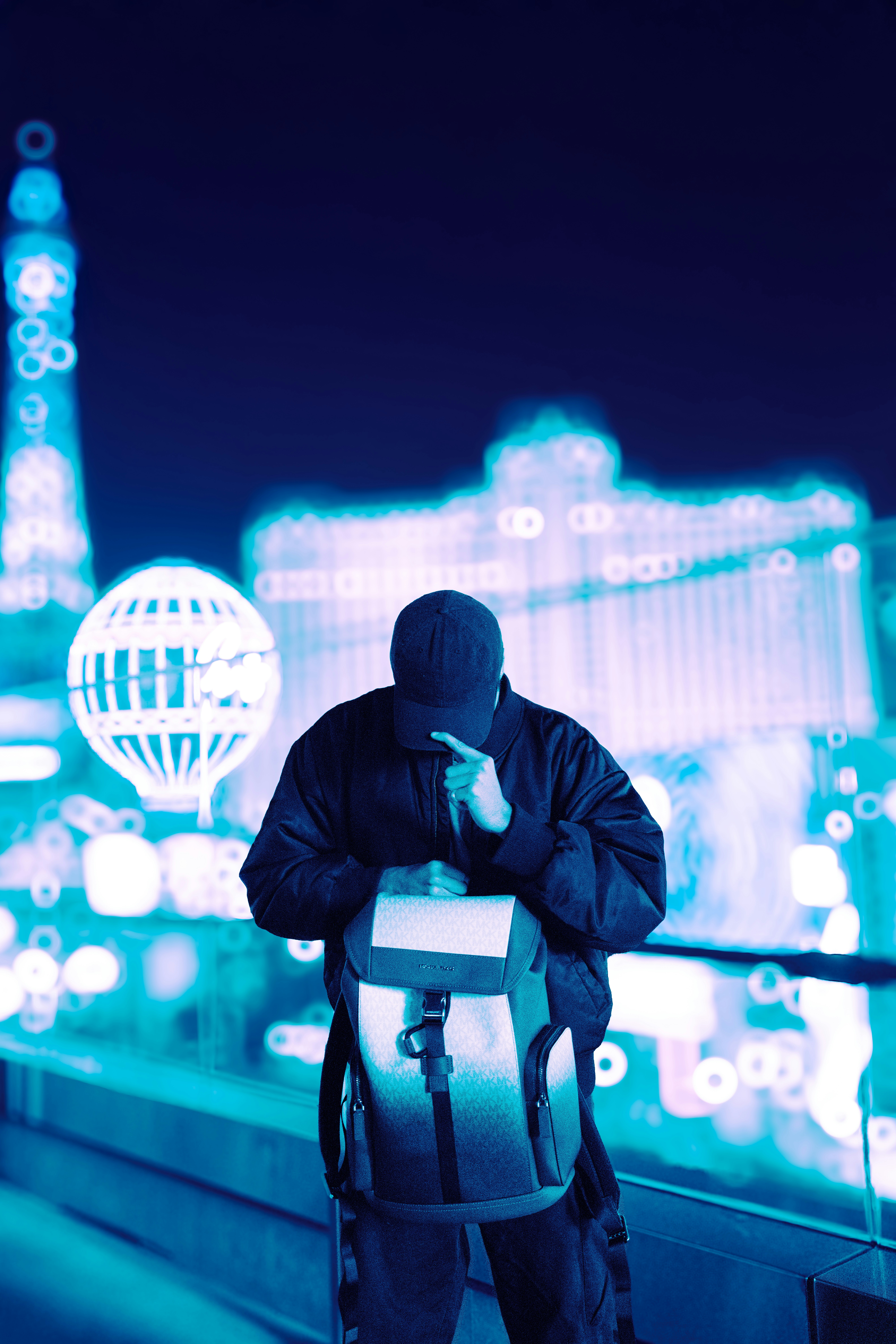 Man with backpack in a neon city at night