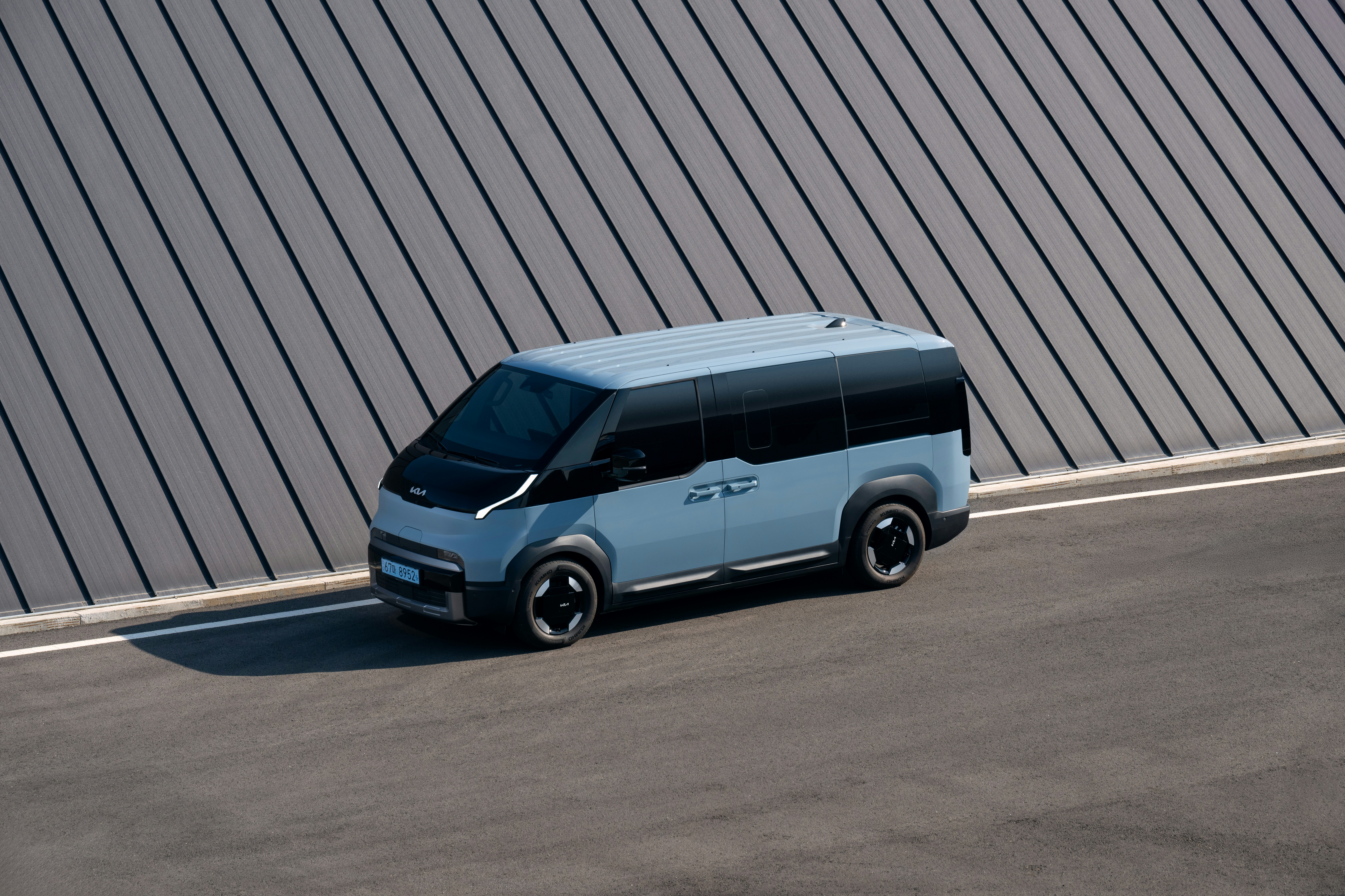 A light blue van parked on asphalt road.