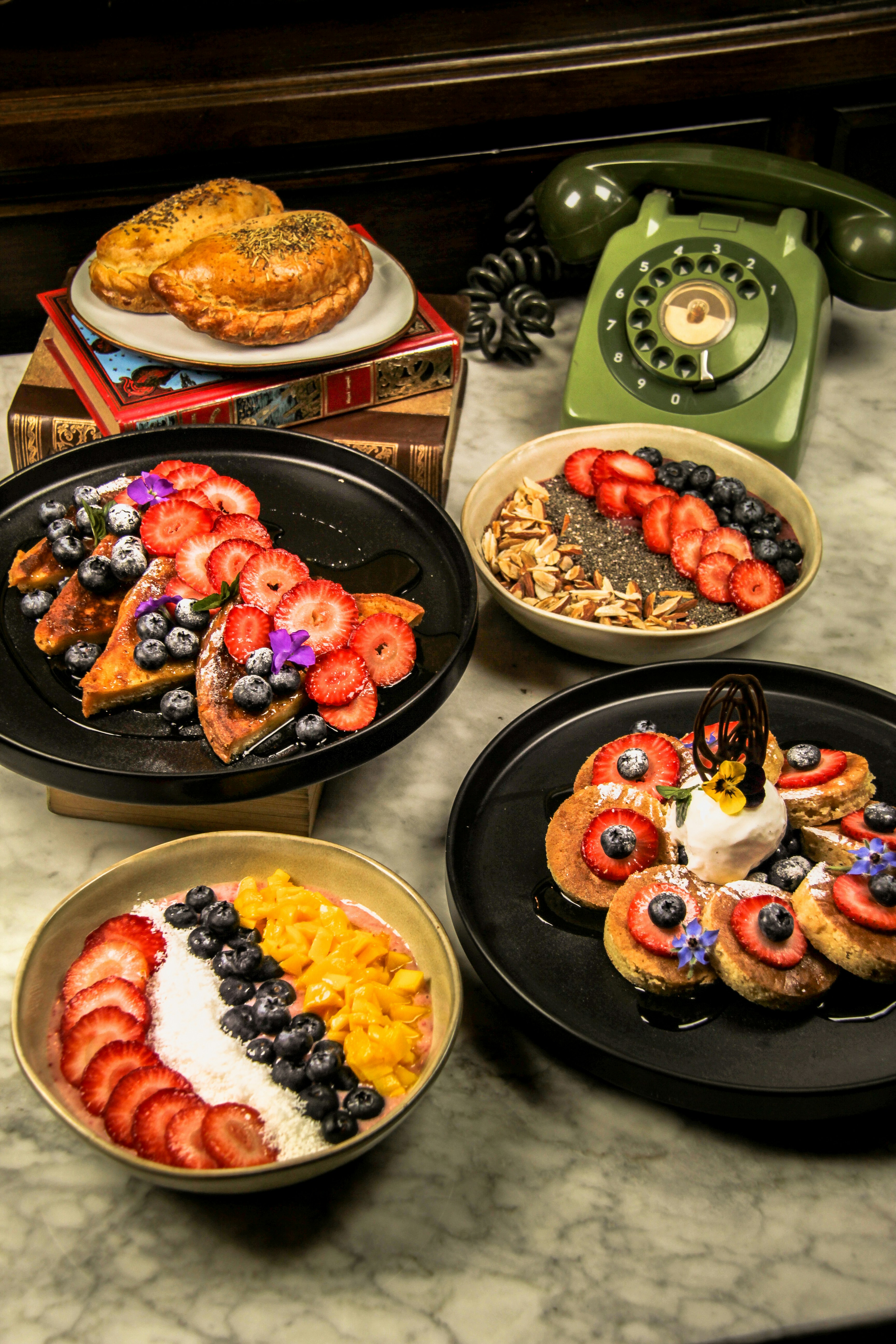 Four delicious breakfast dishes with fruit and toppings.