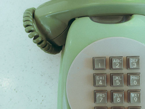 Close-up of a vintage green rotary phone