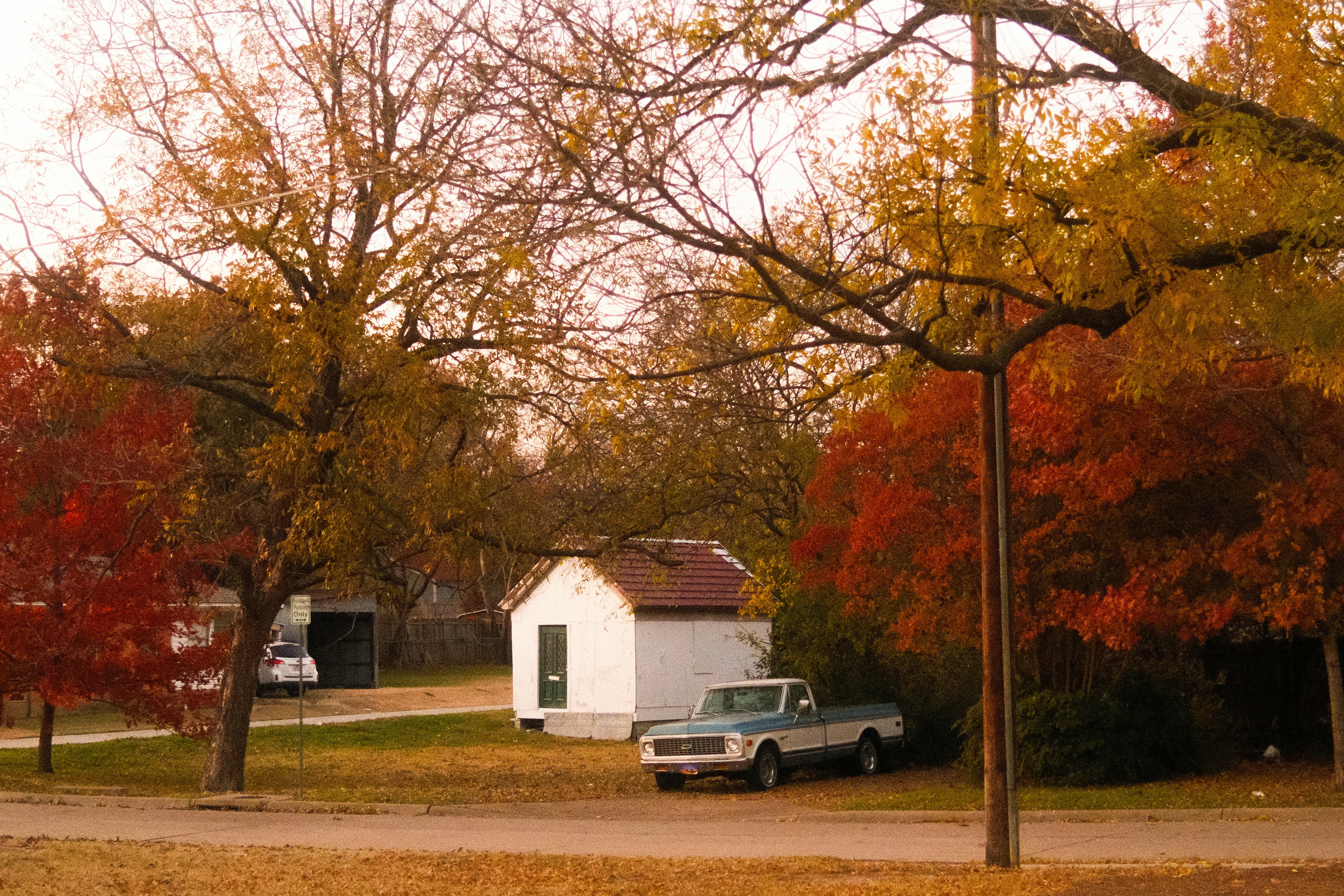 A white truck parked near a small house.