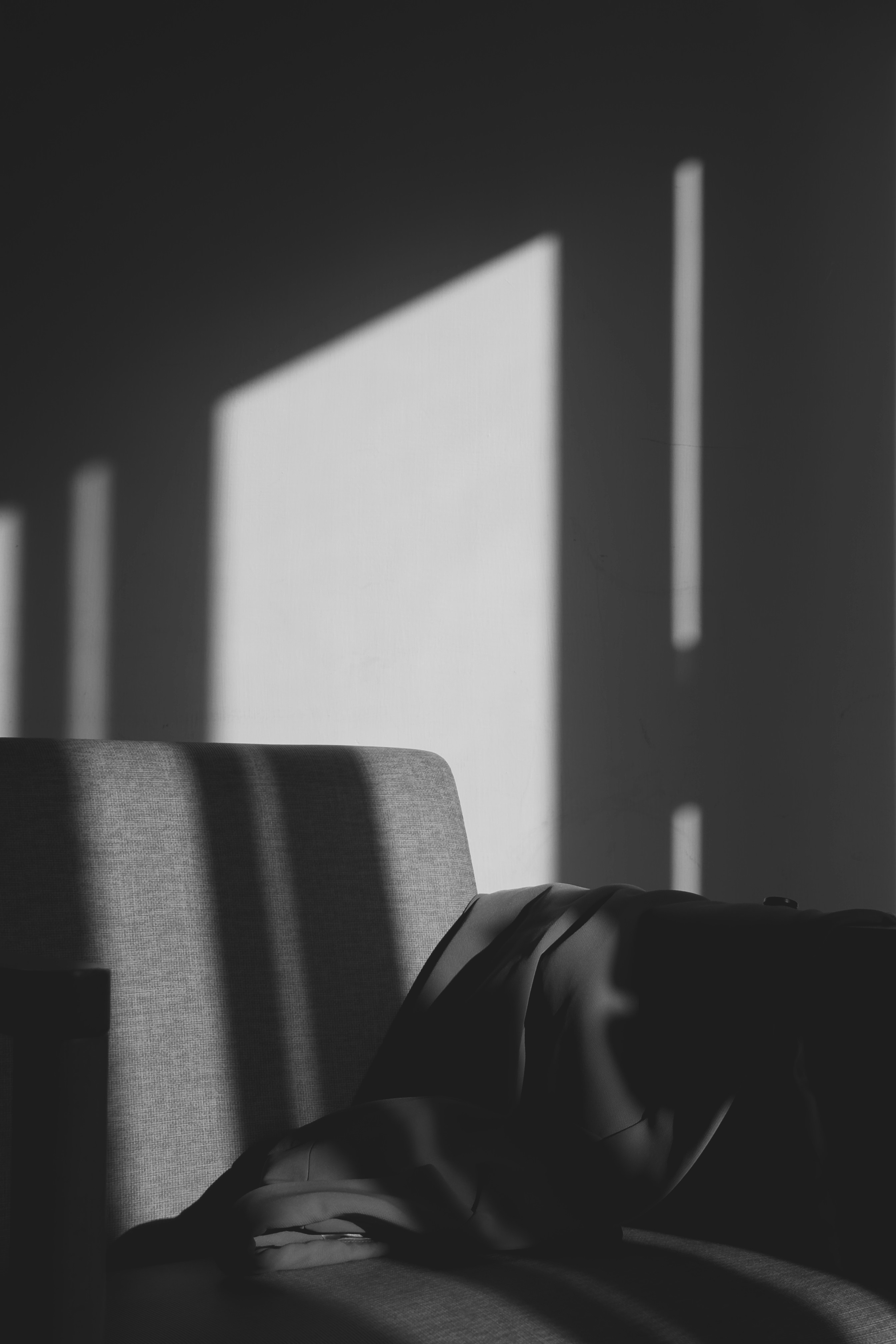 Sunlight streams through blinds onto a chair.