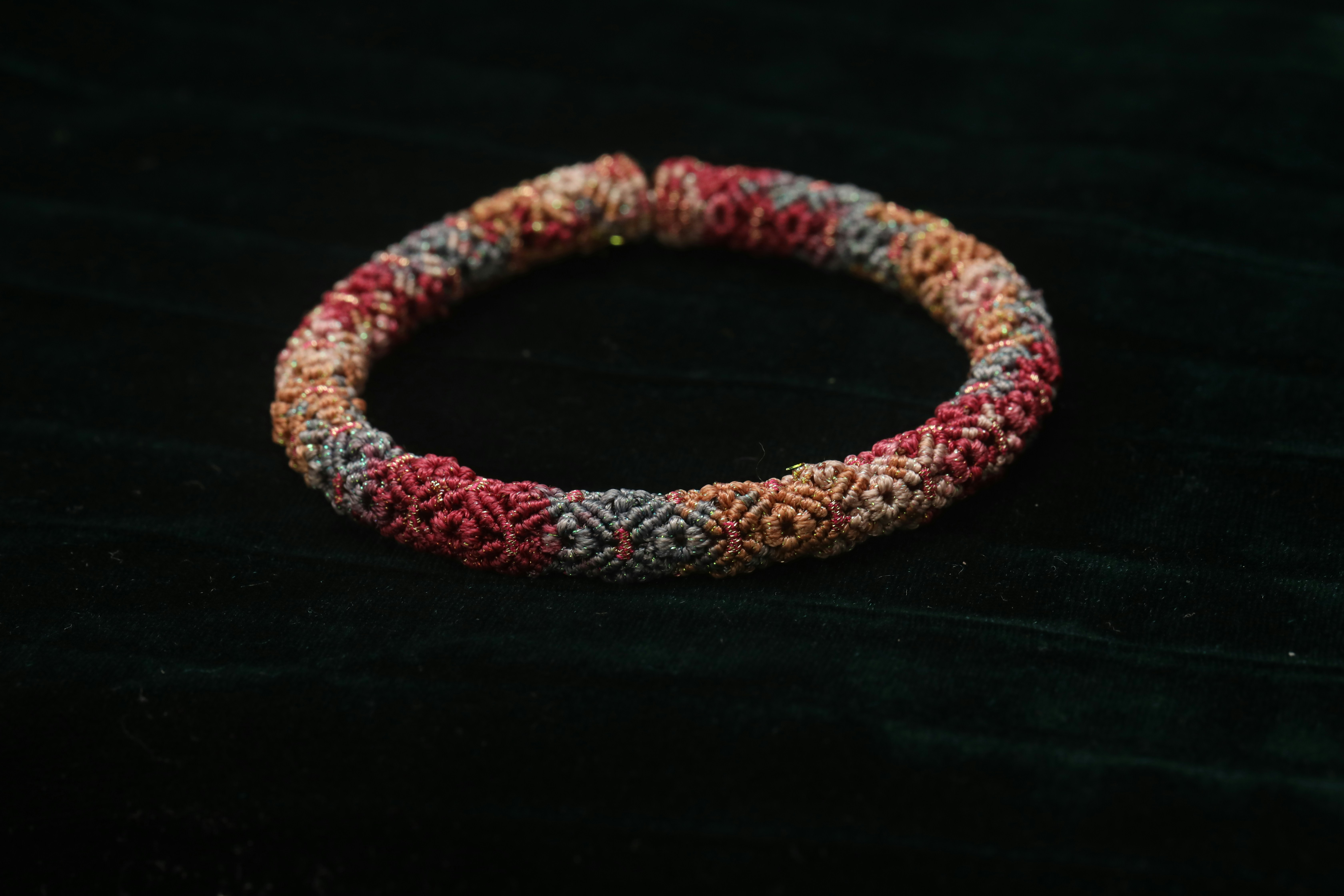 Colorful beaded bracelet on dark green fabric