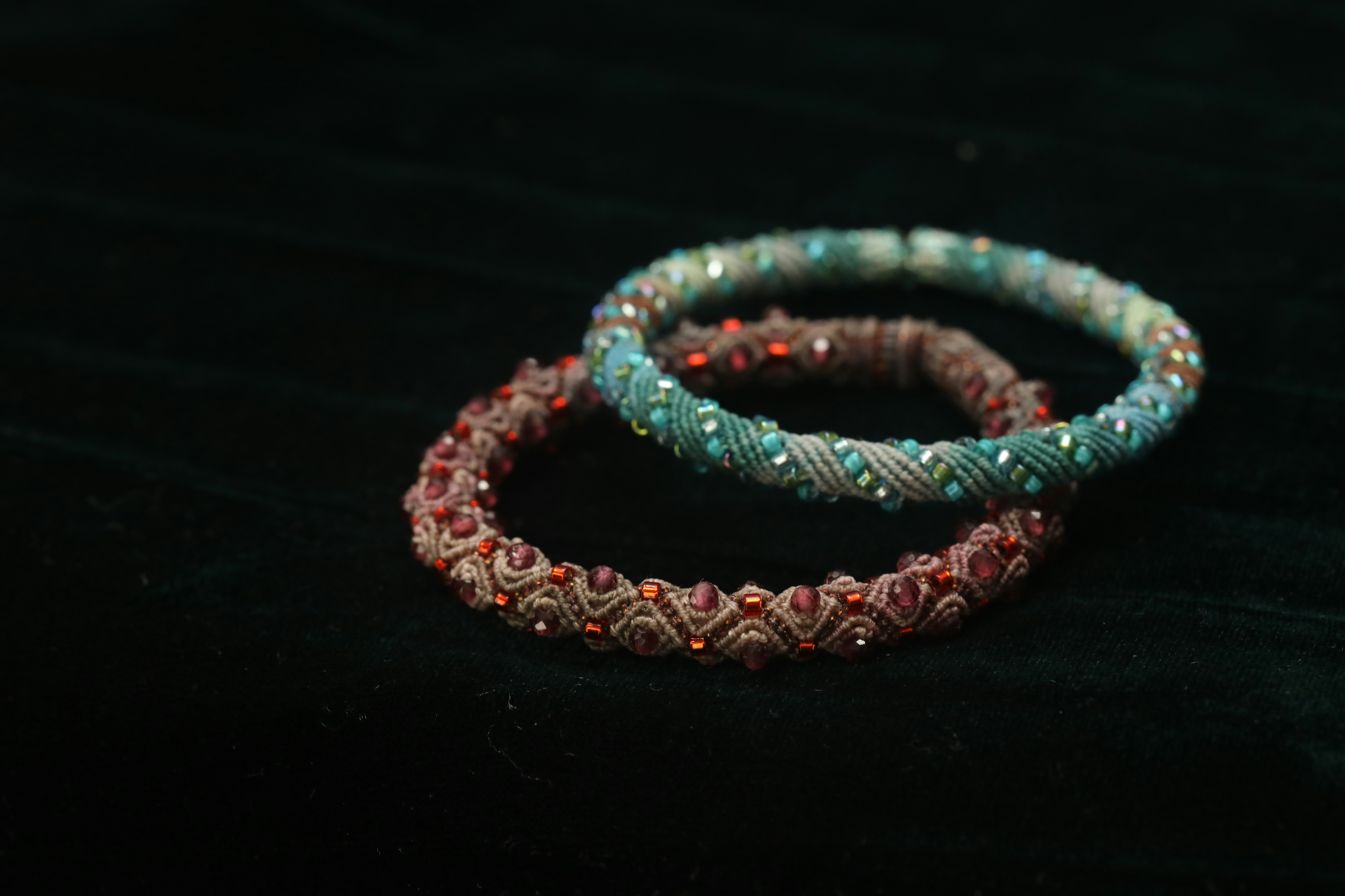 Two beaded bracelets on a dark background