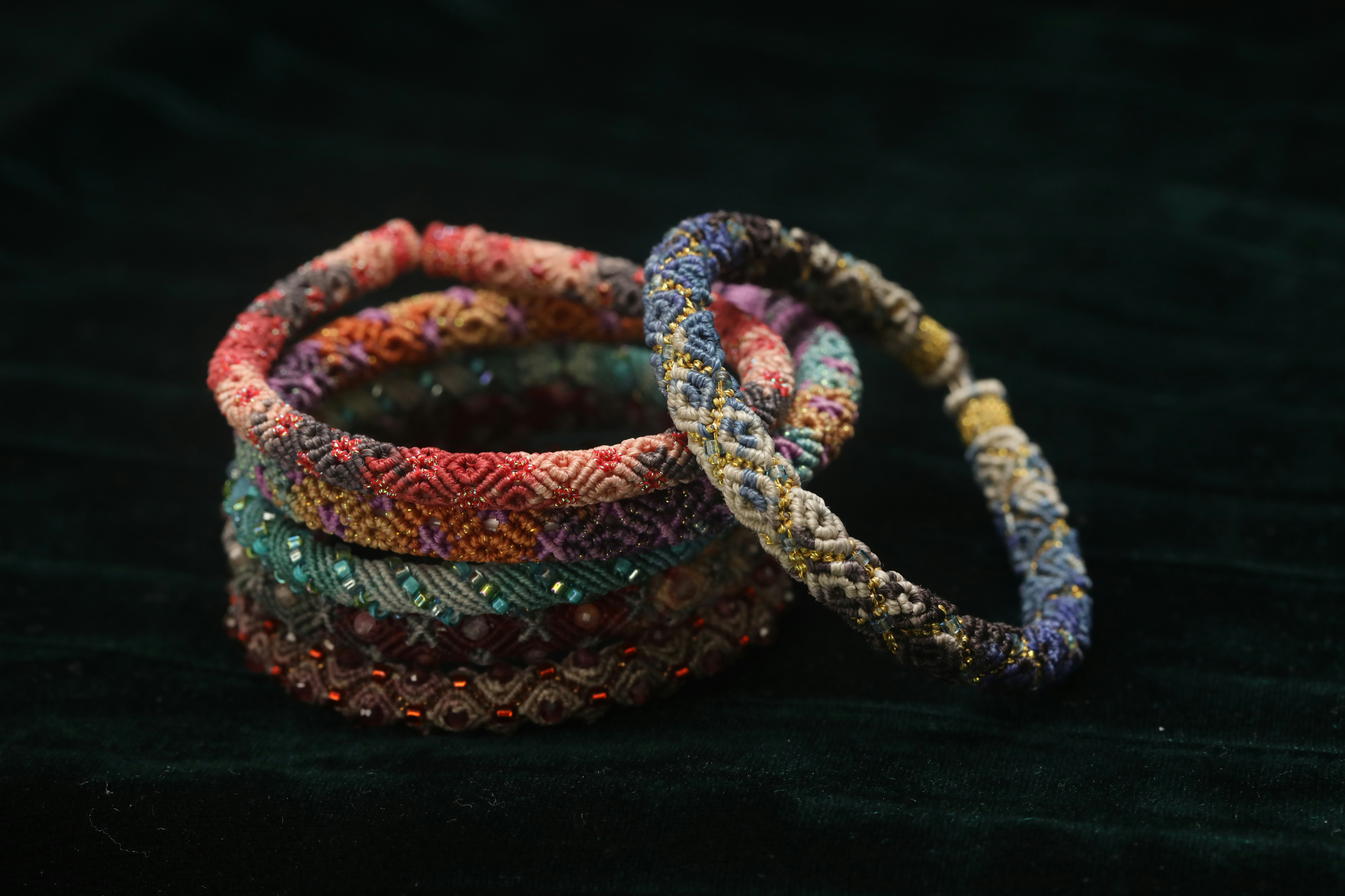 Stack of colorful beaded bracelets on dark fabric