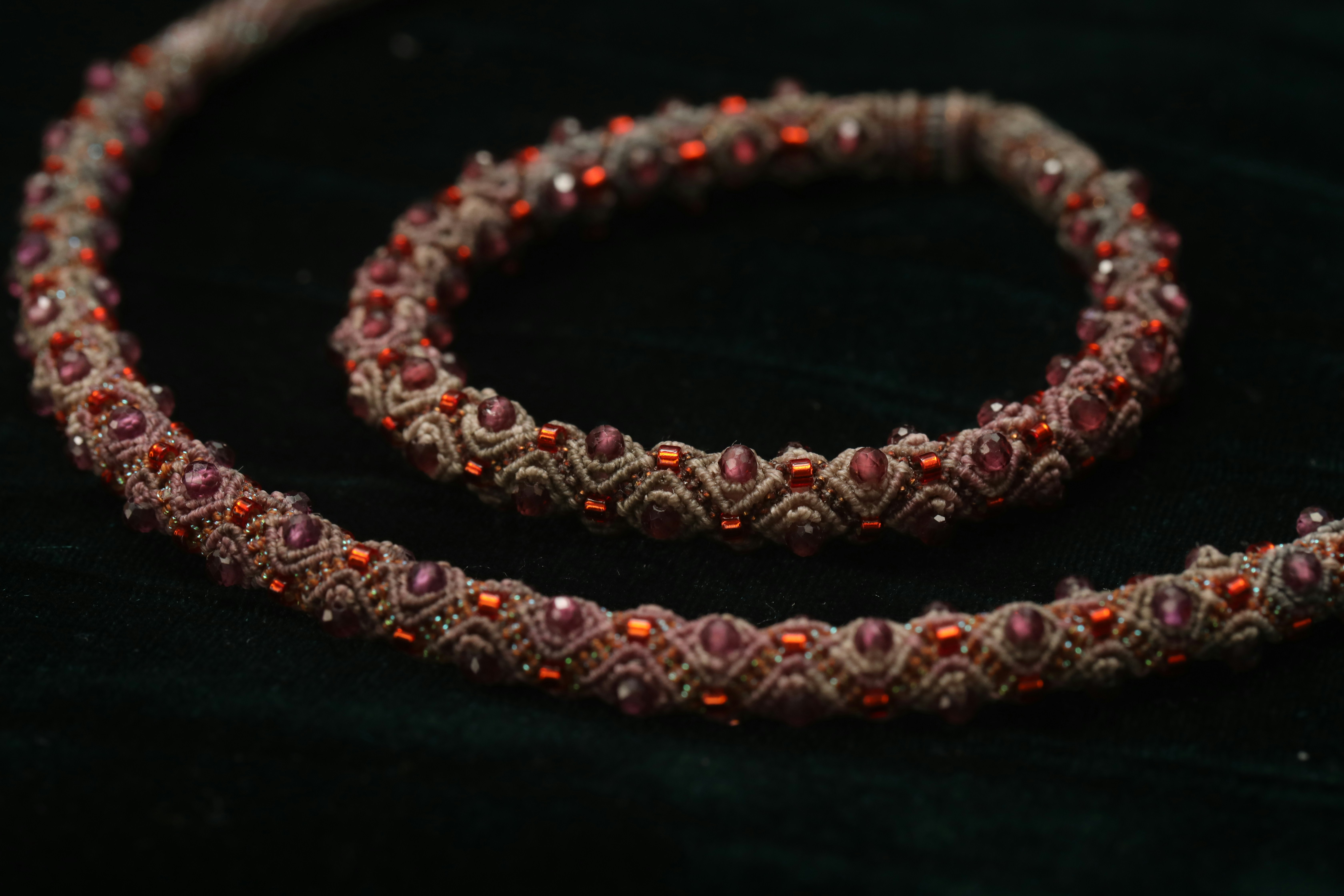 Close-up of brown beaded necklace with red gems