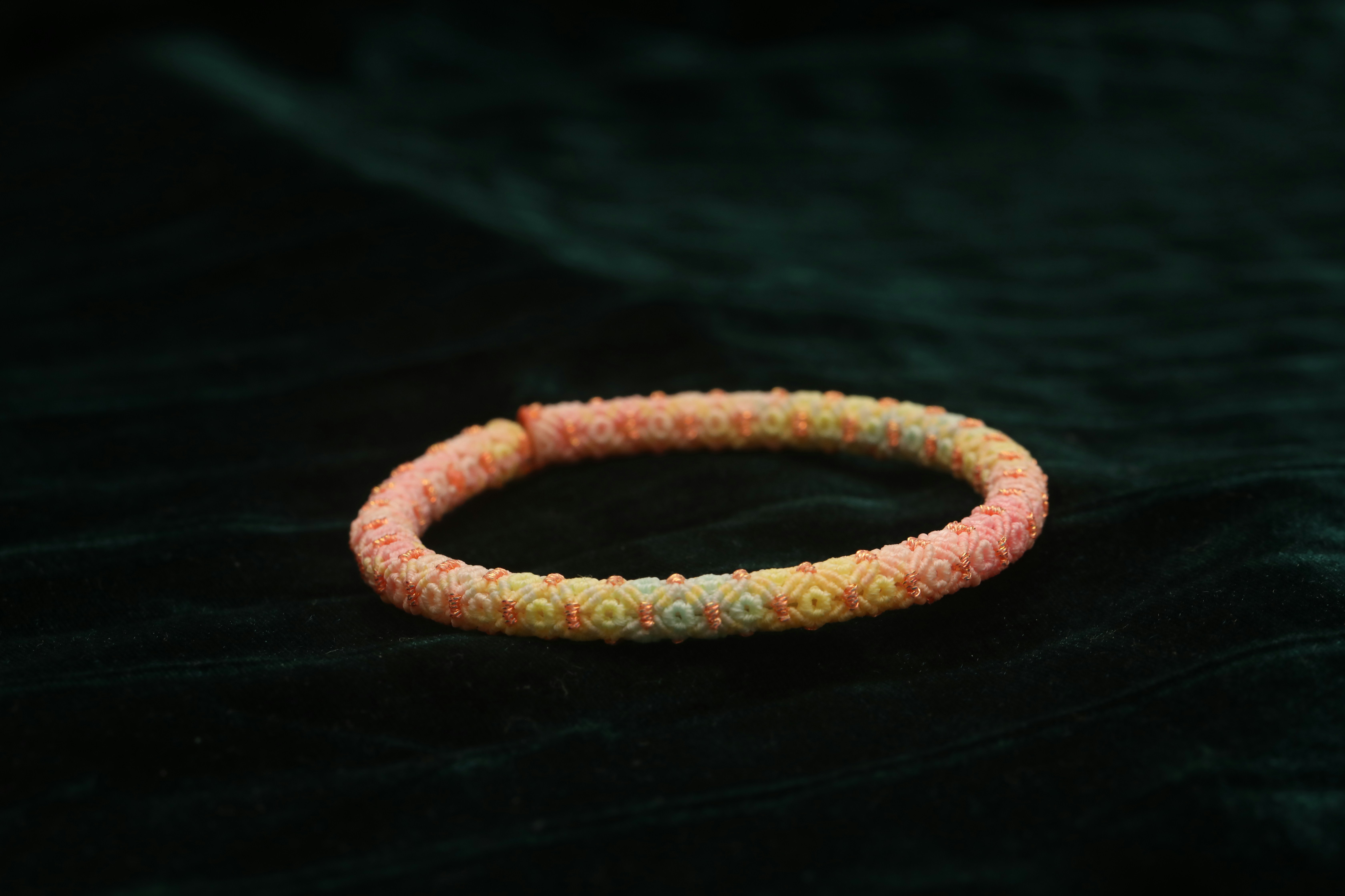 A colorful beaded bracelet on a dark background