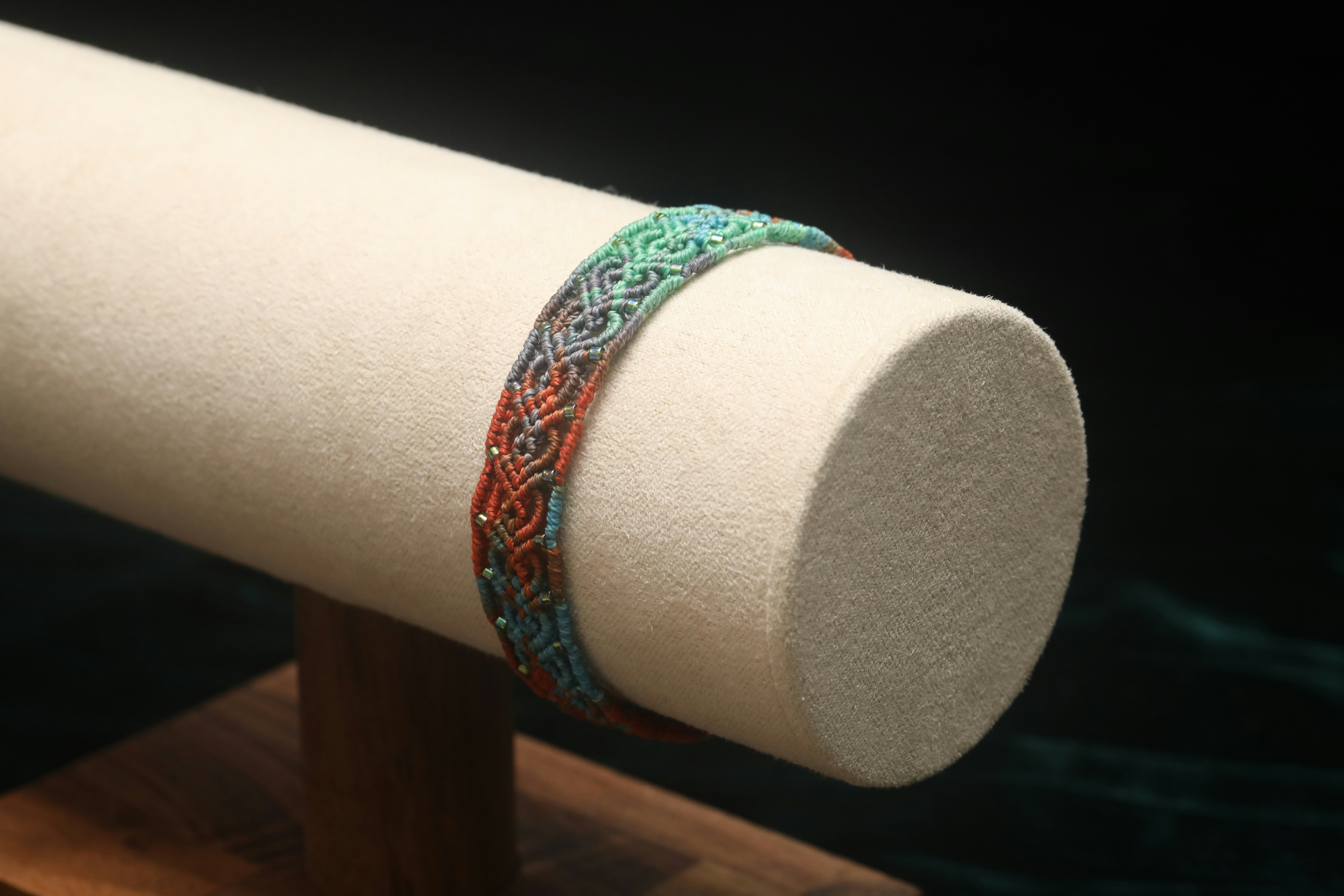A colorful woven bracelet on display stand