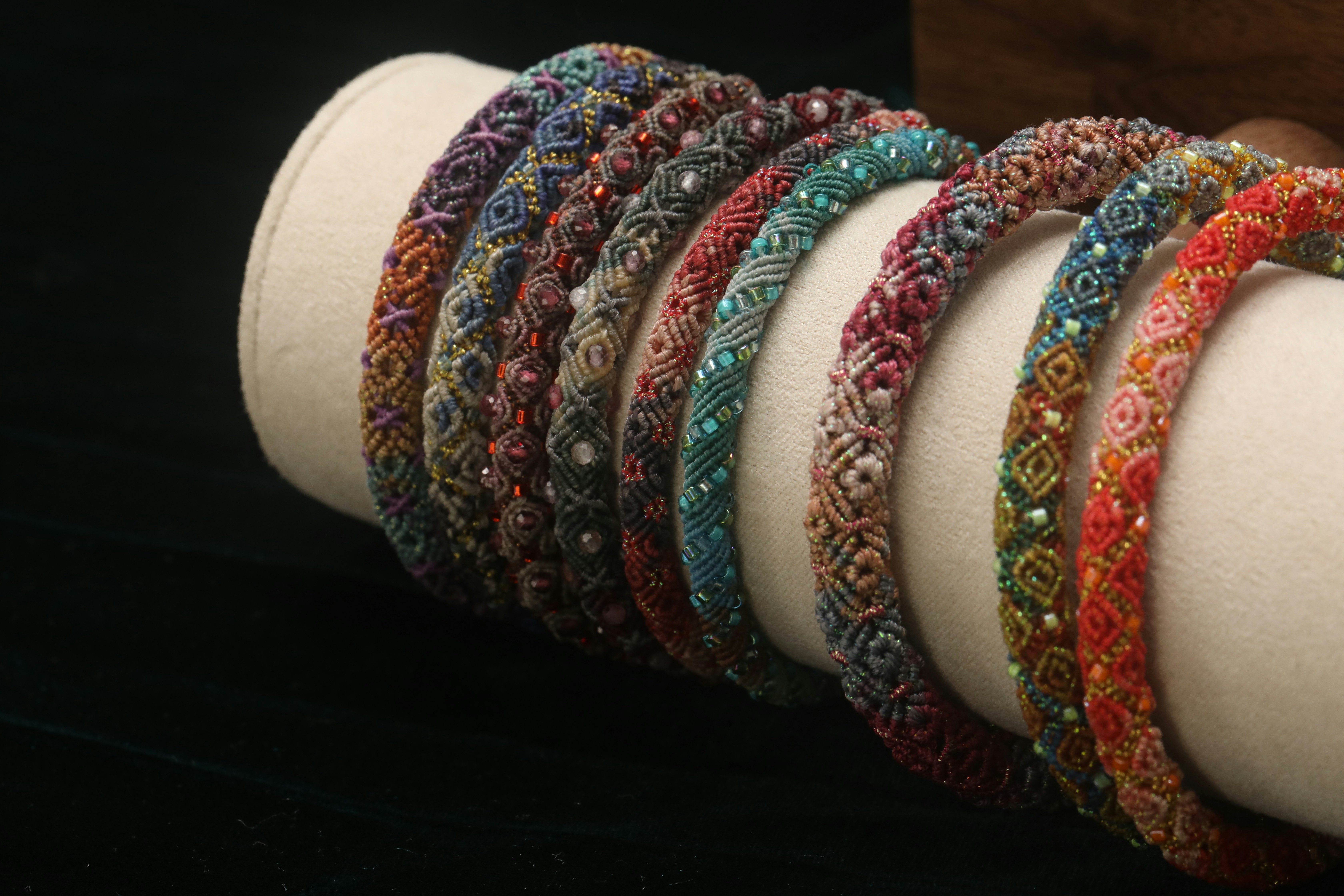 Colorful beaded bracelets arranged on a display stand.