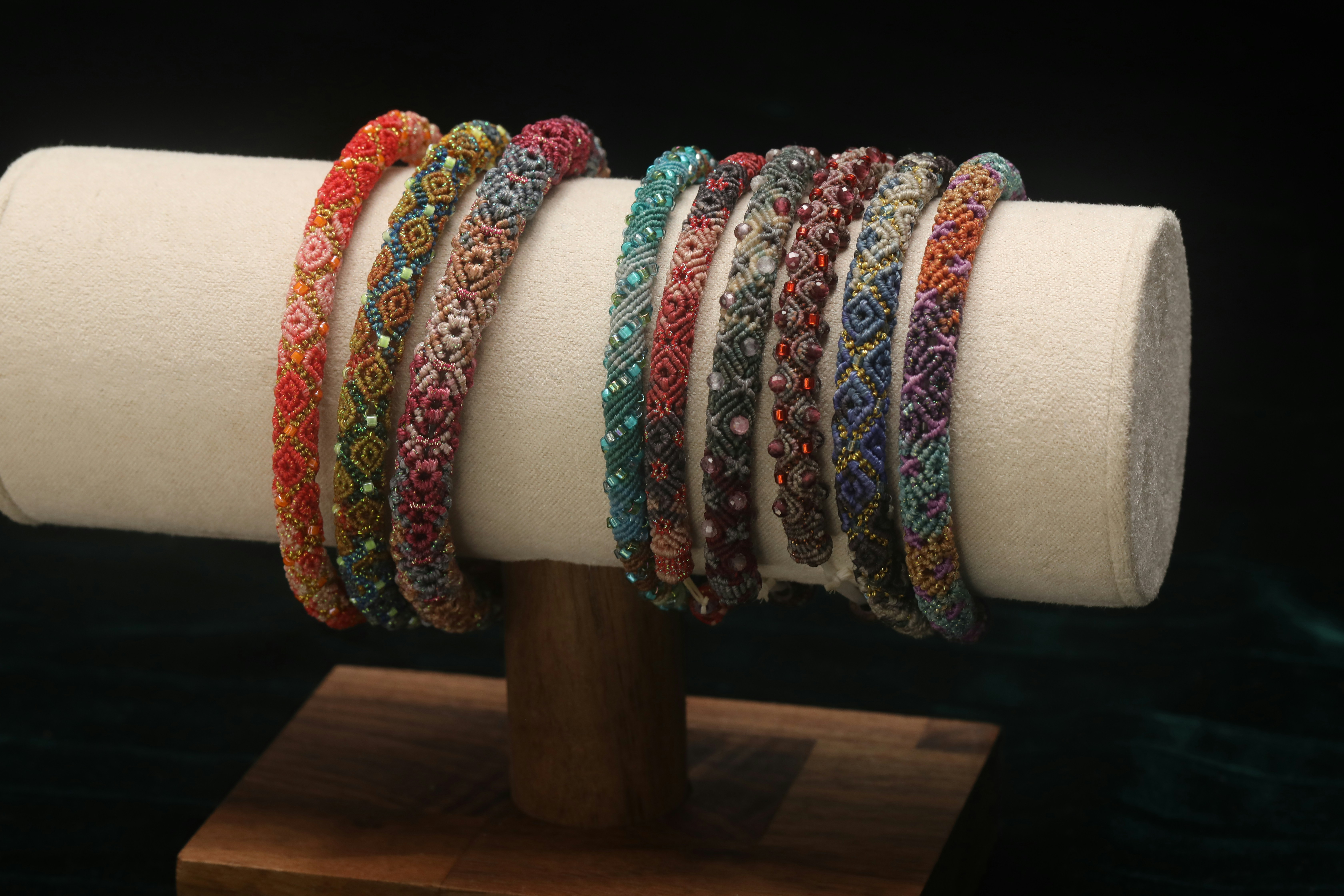 Colorful beaded bracelets displayed on a stand