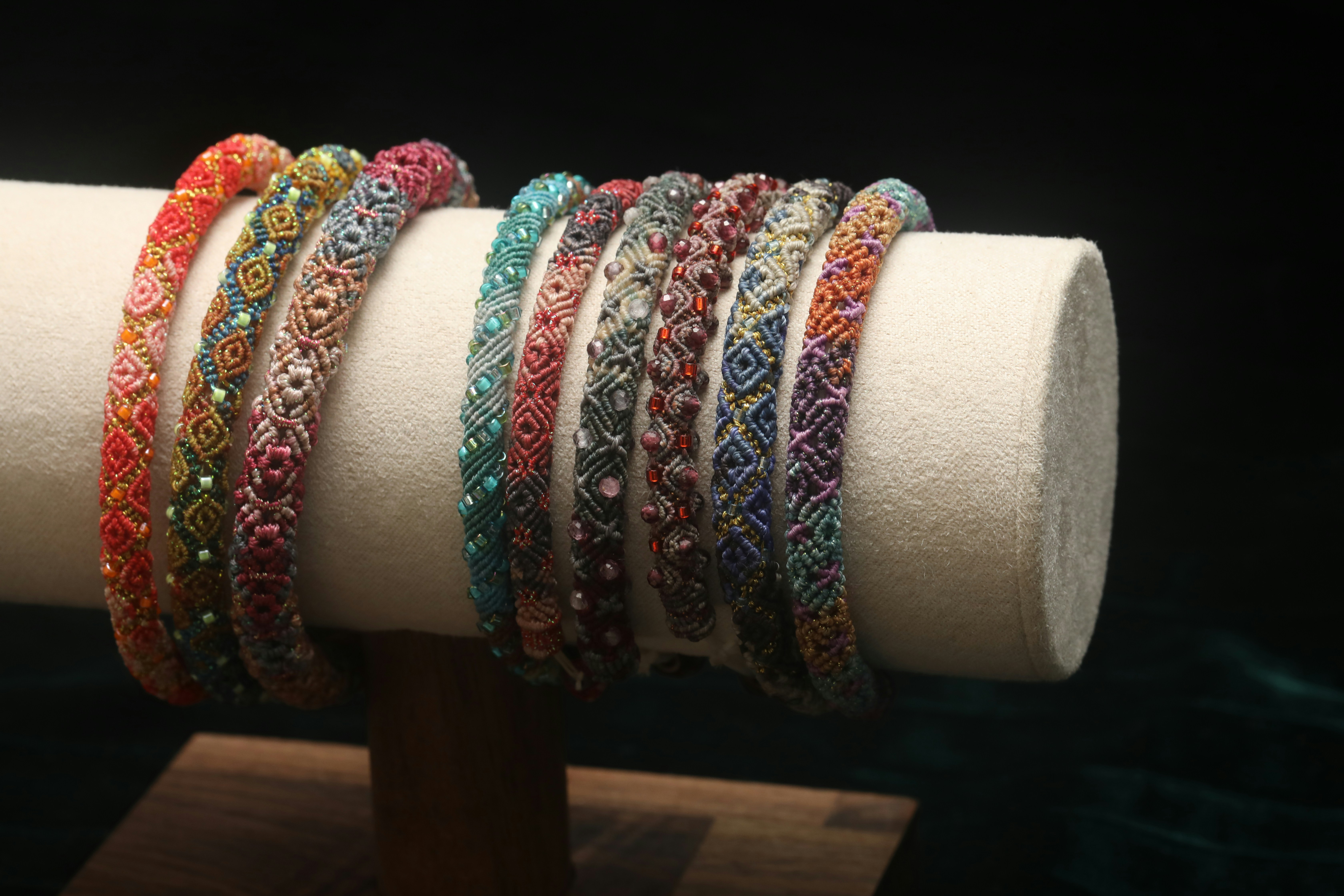 Colorful beaded bracelets arranged on a display stand.