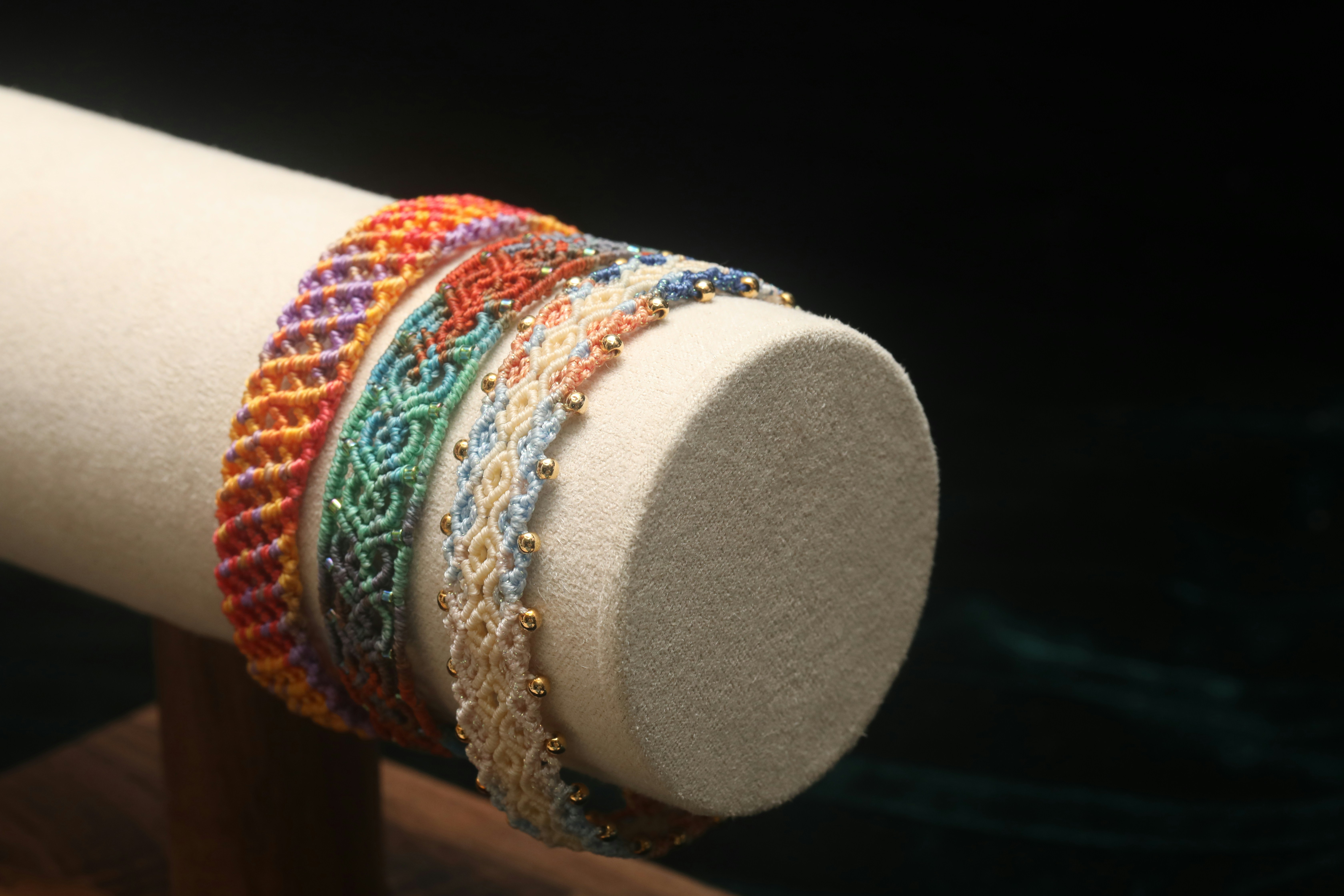 Colorful woven bracelets displayed on a stand