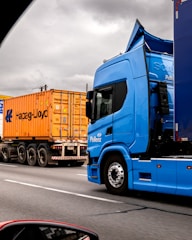 Two trucks on a highway under cloudy sky
